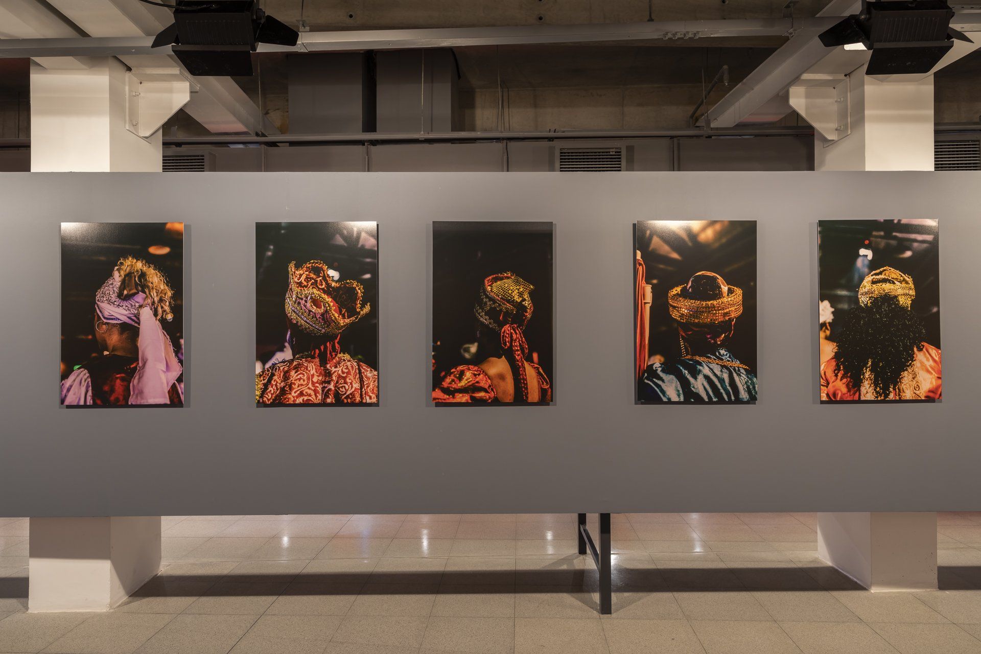 Uma fileira de pinturas está pendurada na parede de uma sala.