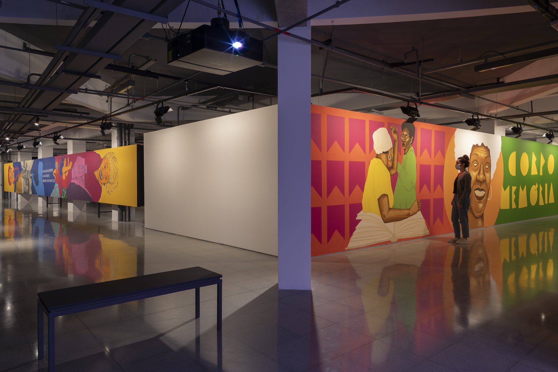 Uma grande sala vazia com muitas pinturas nas paredes.