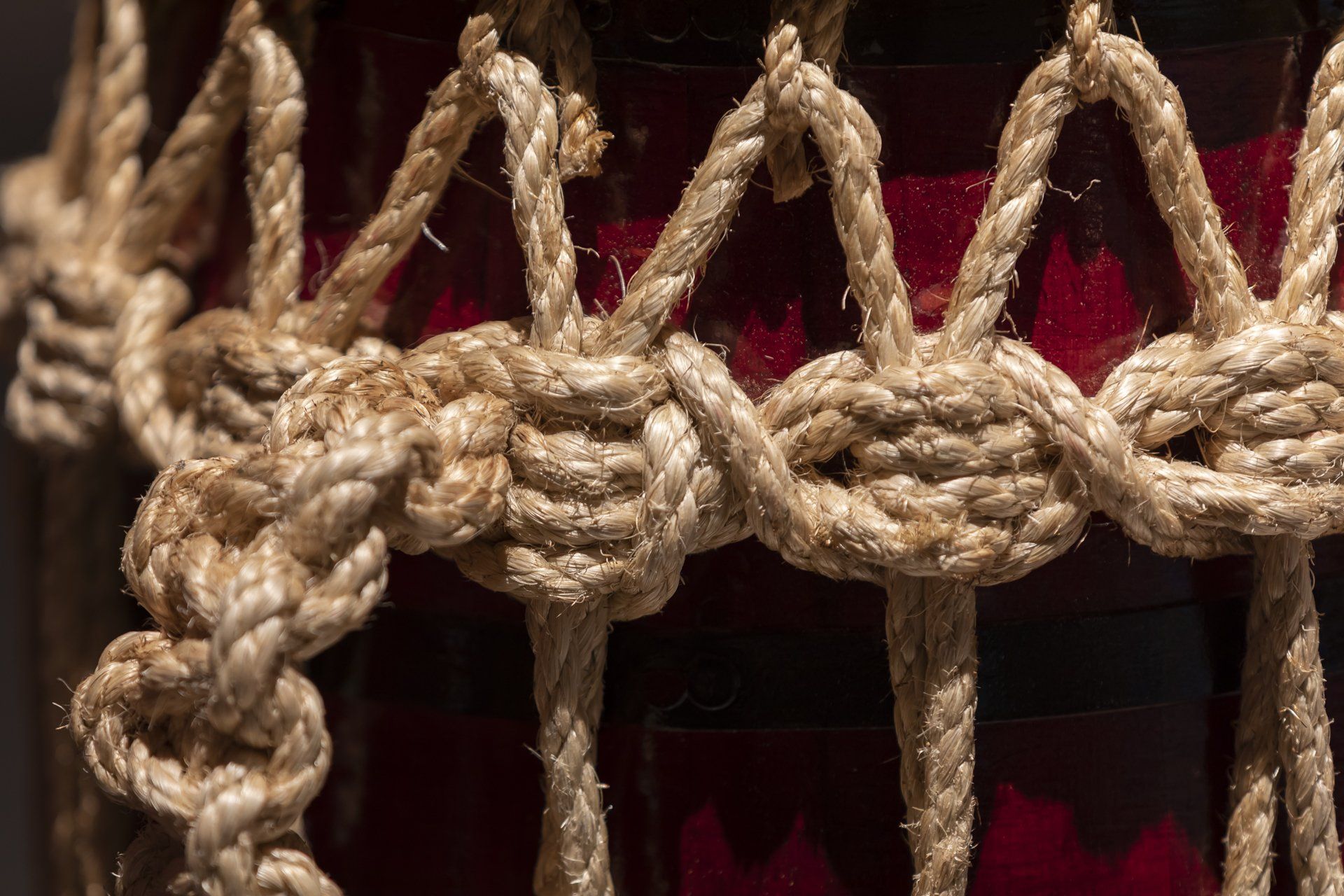 Um close de uma cerca de corda em torno de um vidro vermelho.