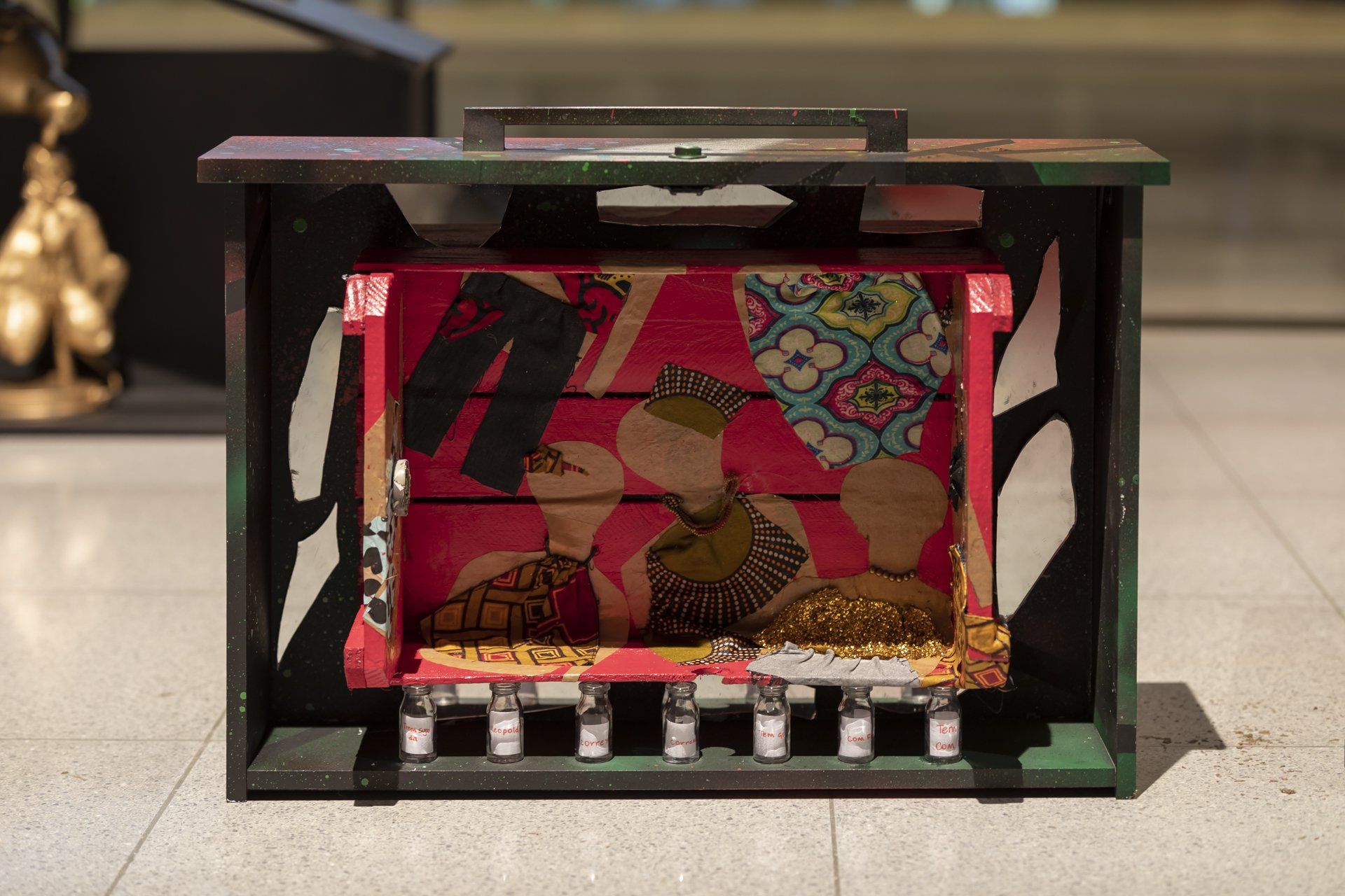 Uma caixa de madeira com uma pintura está apoiada no chão de ladrilhos.