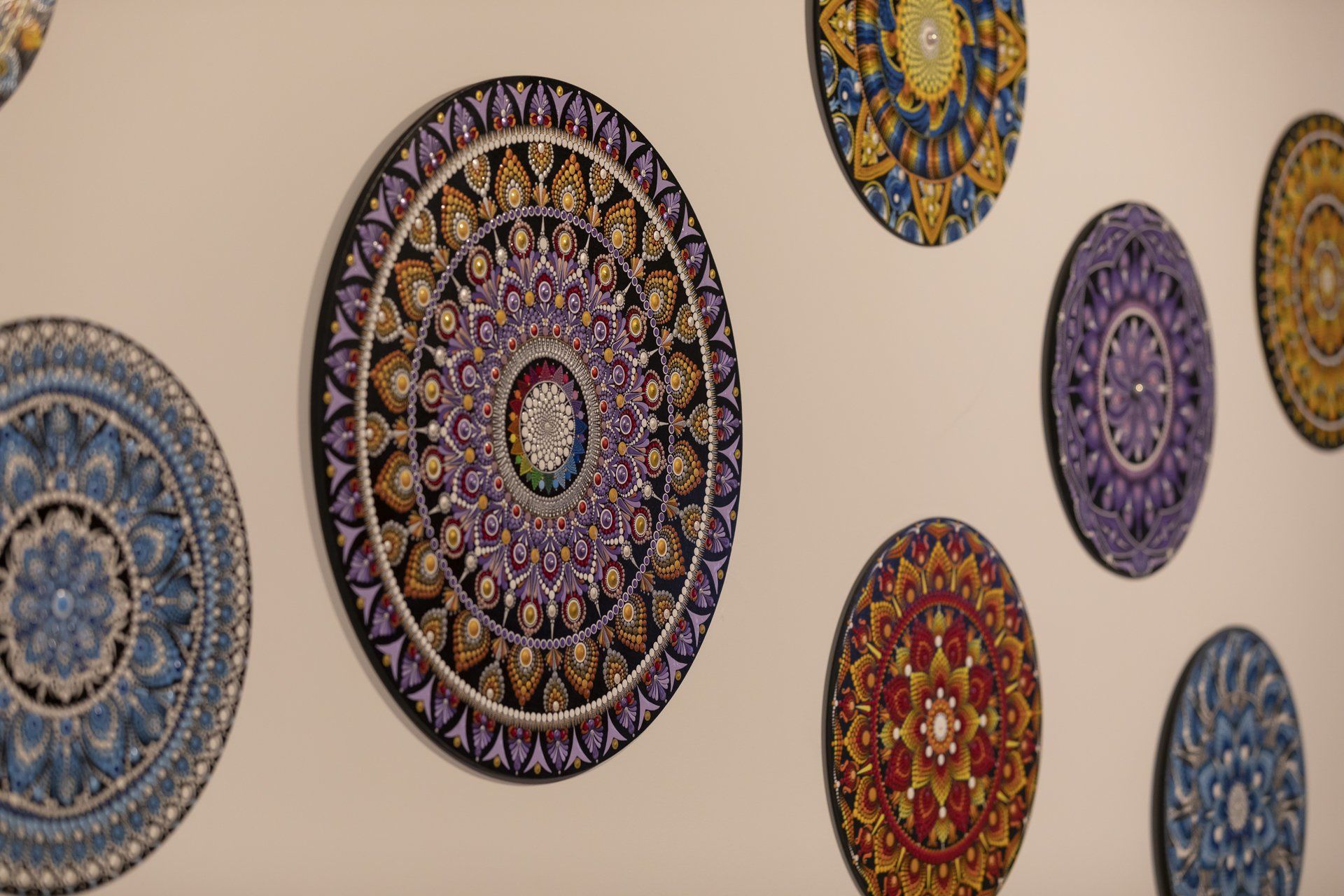 Um grupo de pratos com um desenho circular está pendurado na parede.