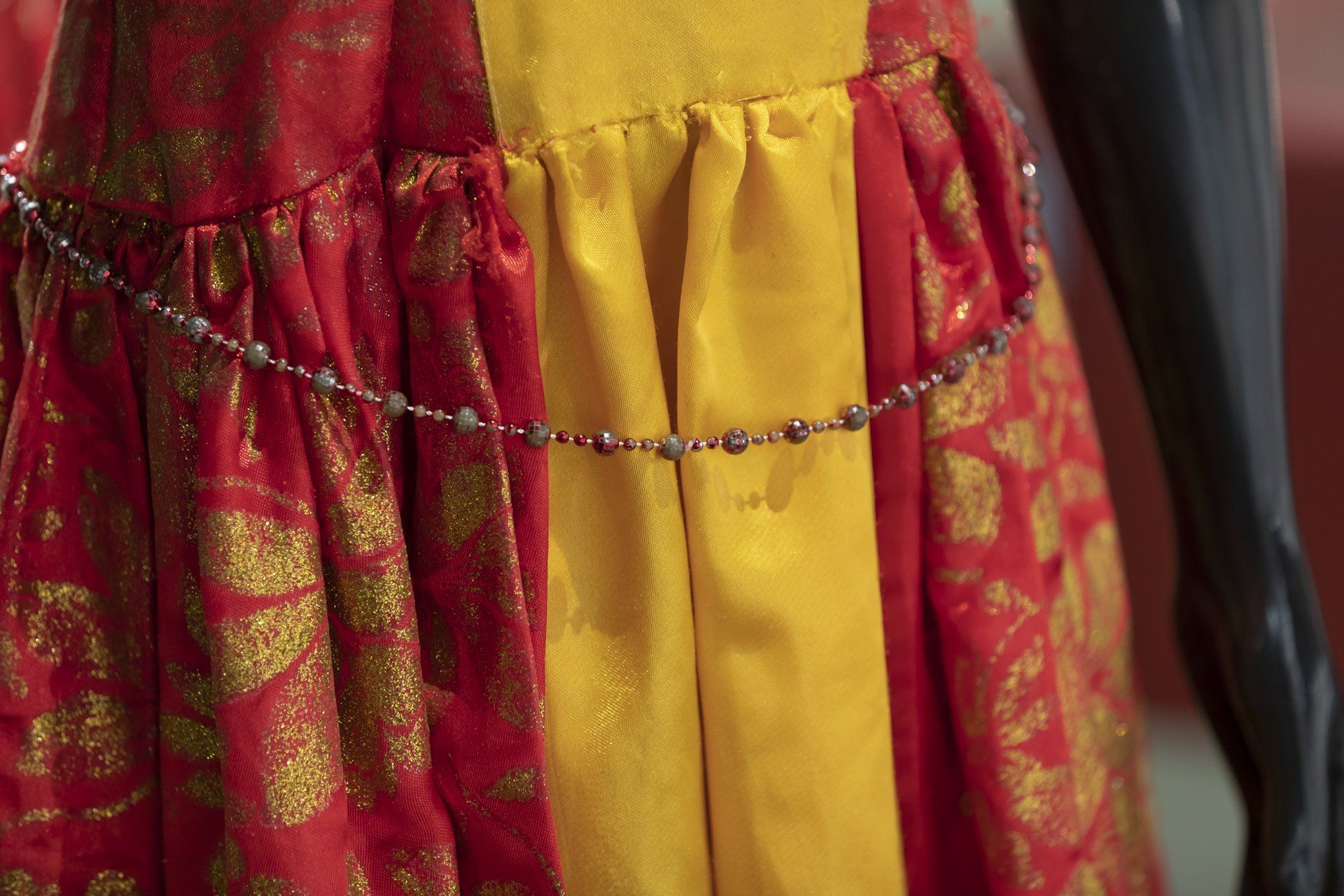 Um close de um vestido vermelho e amarelo em um manequim.