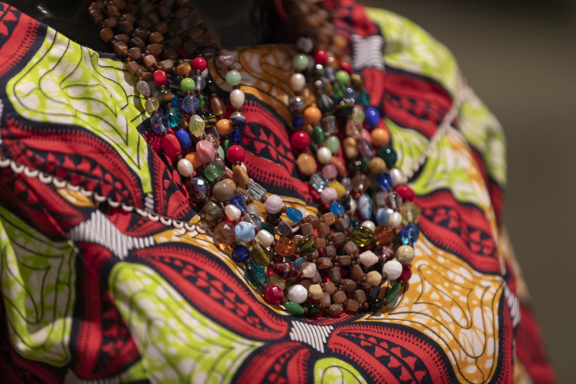 Um close de uma mulher usando um colar de miçangas.