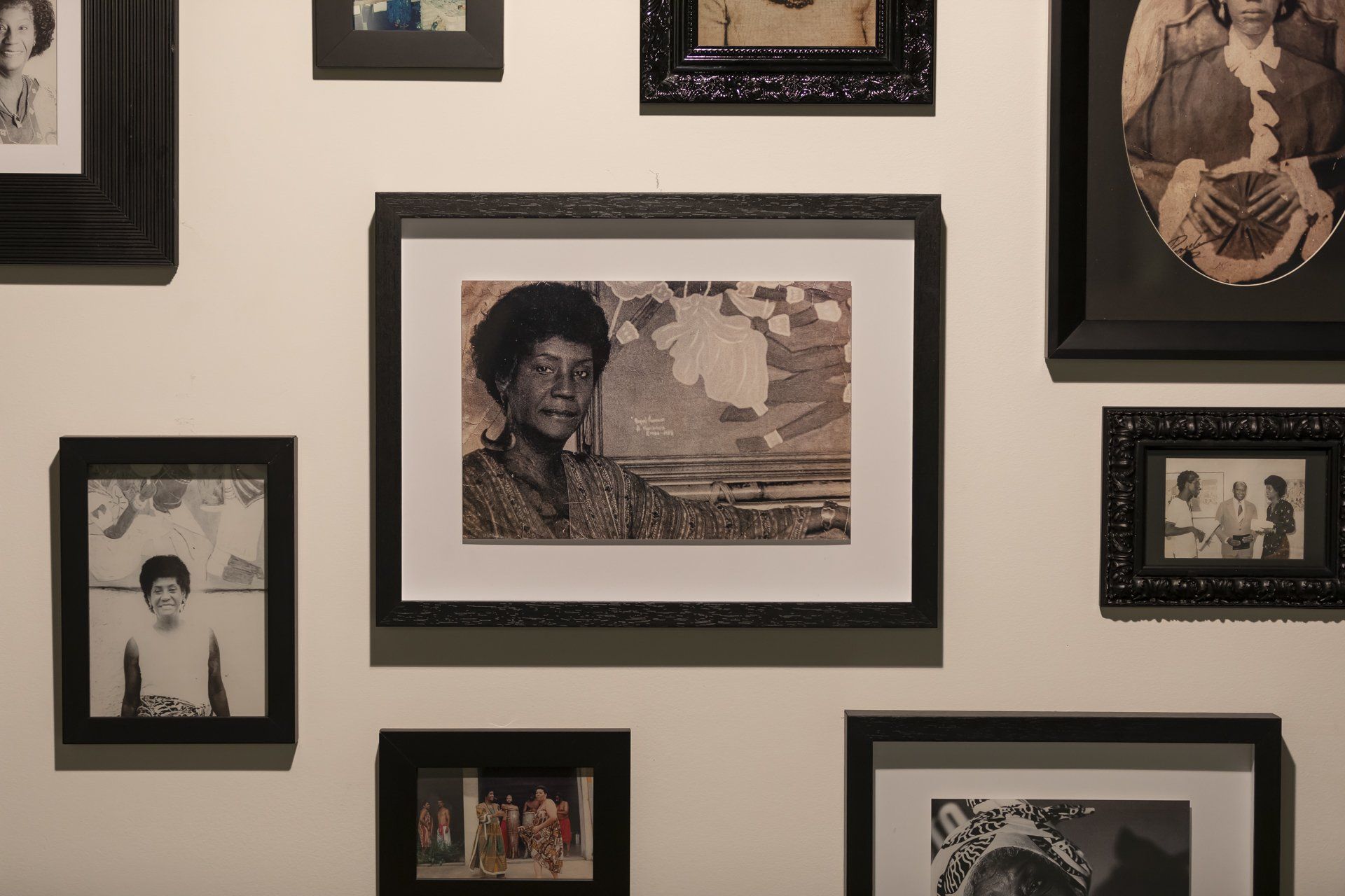 Uma parede com muitas fotos emolduradas