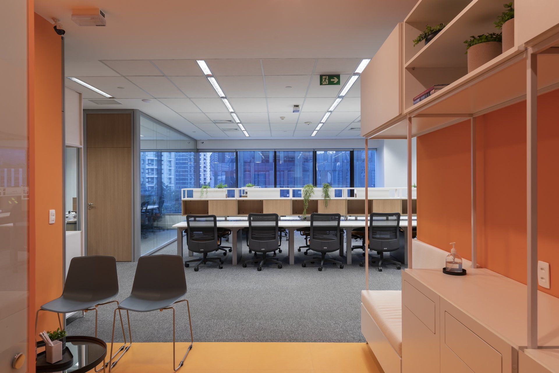 Um grande escritório com muitas mesas e cadeiras.