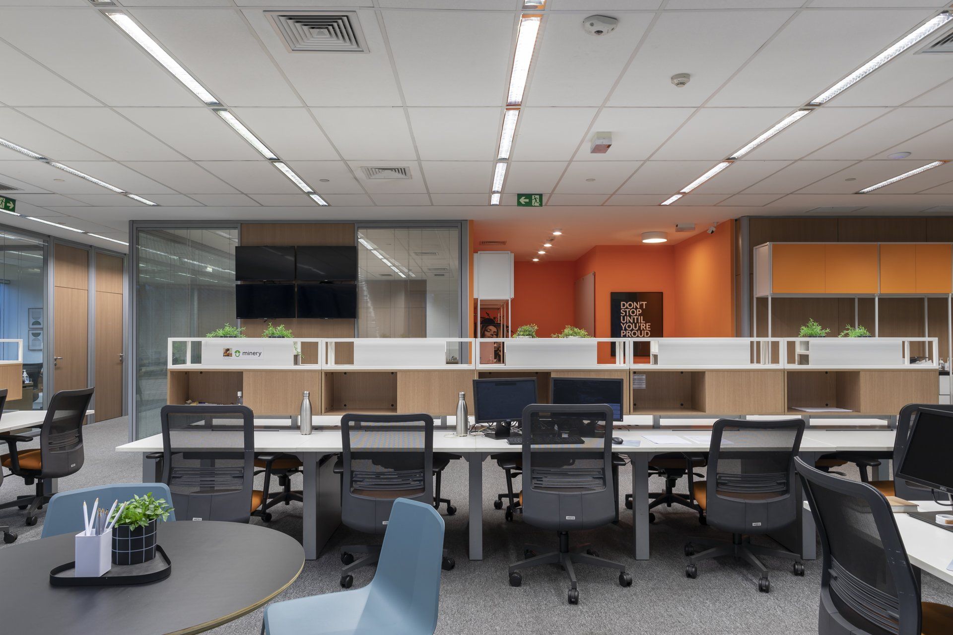 Um grande escritório com muitas mesas e cadeiras.