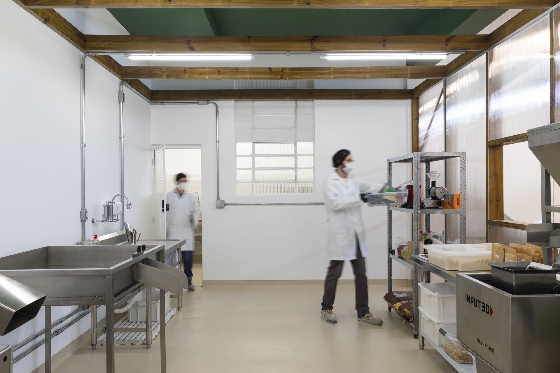 Um homem com jaleco está parado na cozinha.