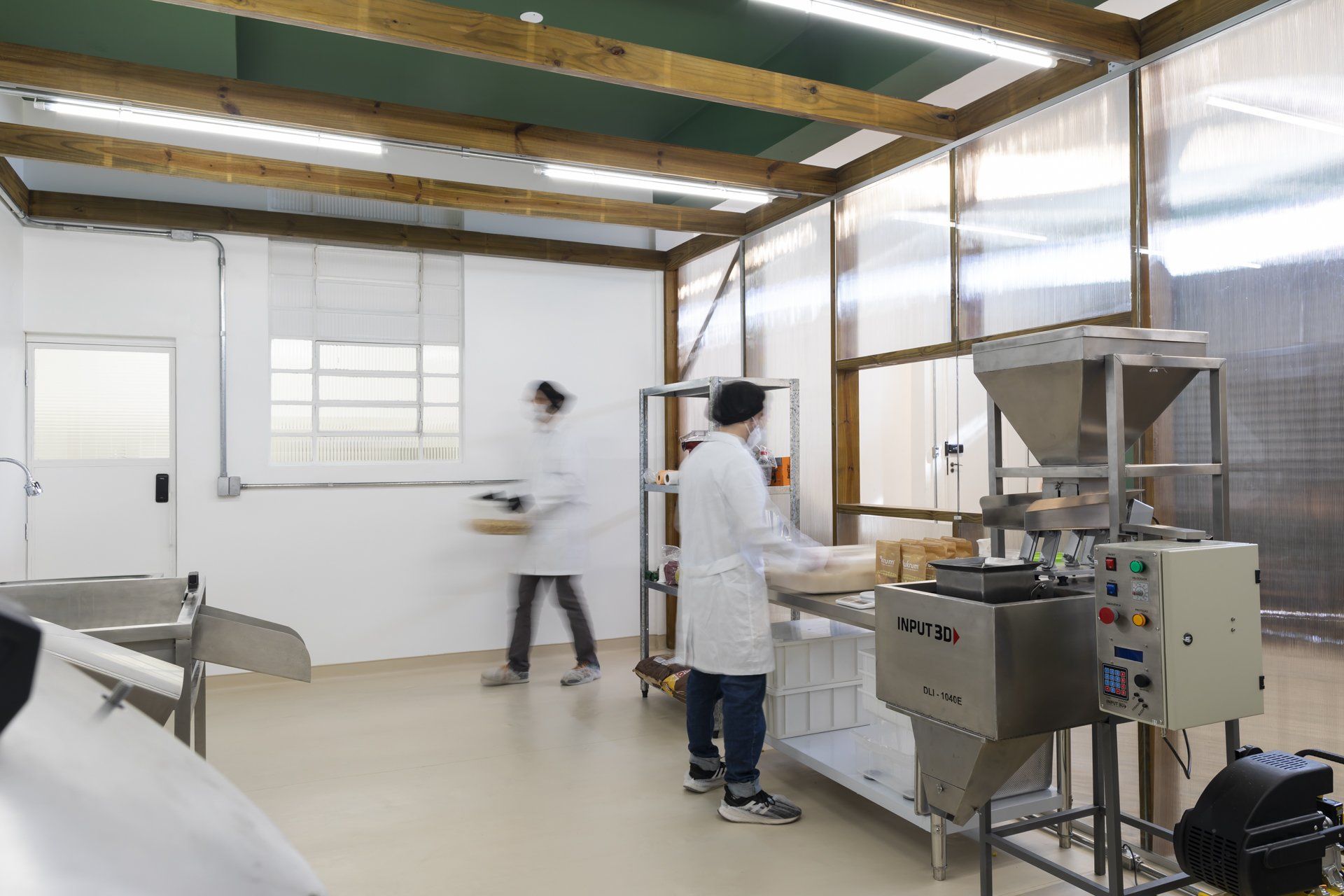 Um homem com jaleco está trabalhando em uma fábrica.