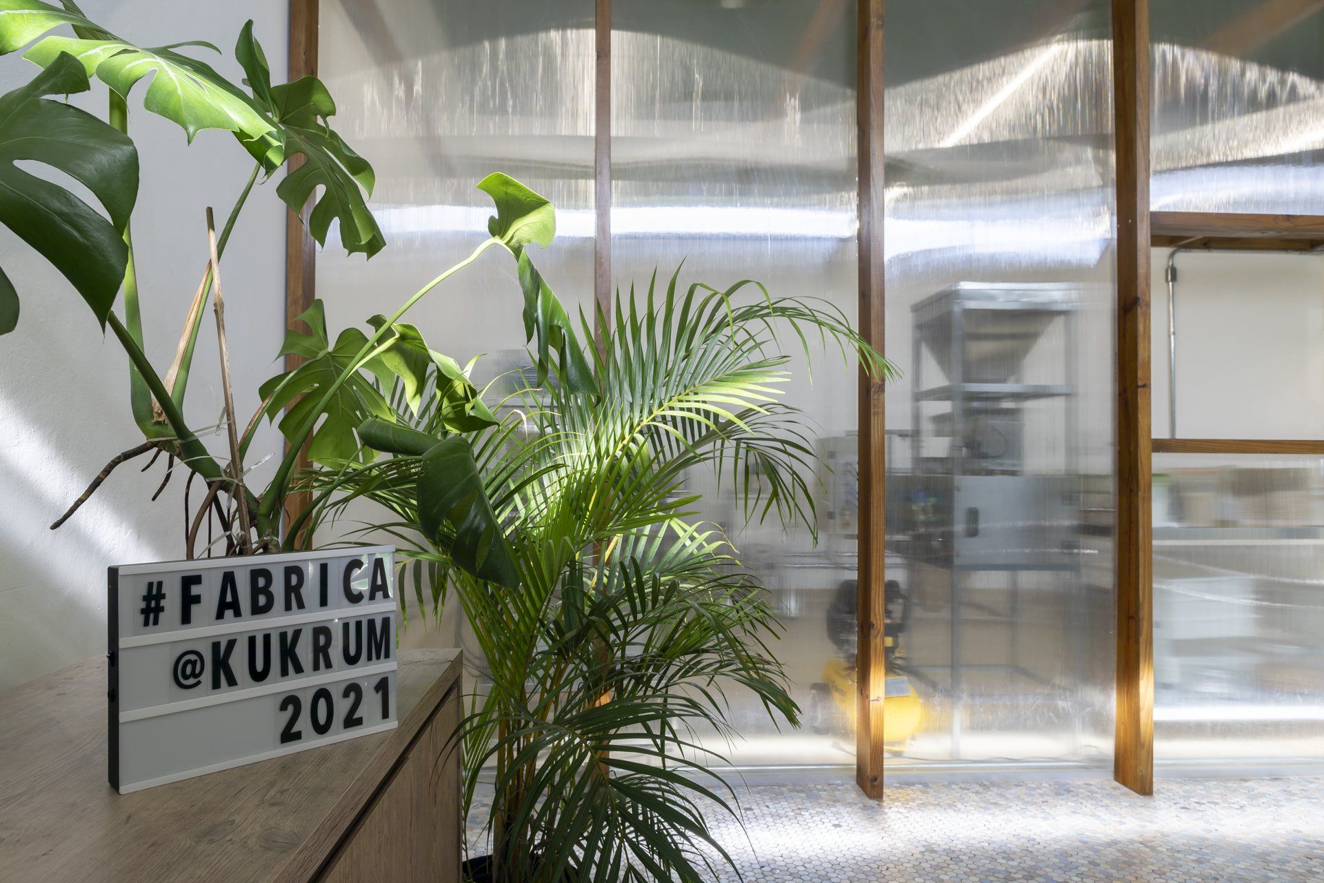 Uma placa na lateral de um prédio com uma planta na frente.