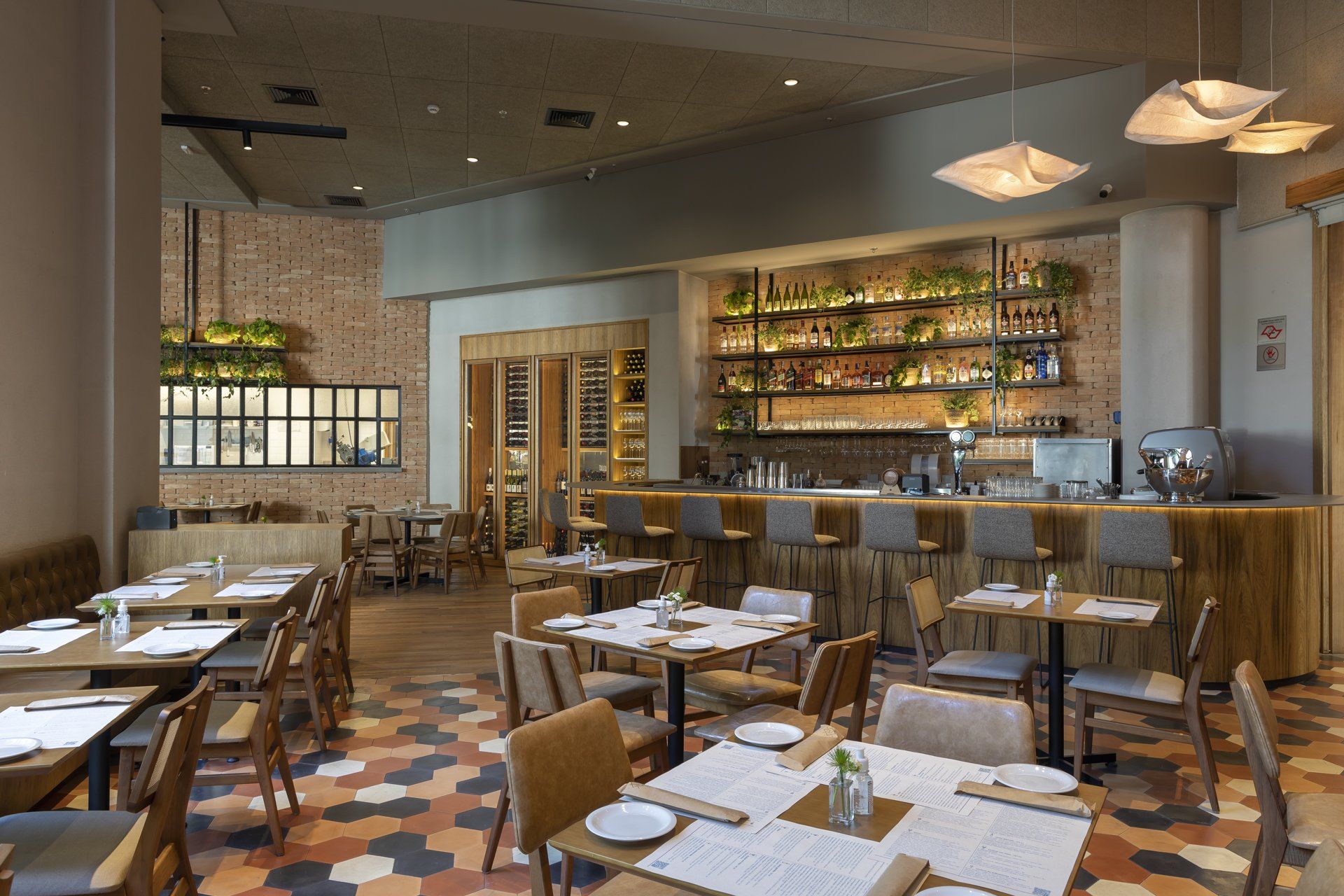 Um restaurante com mesas e cadeiras e um bar.