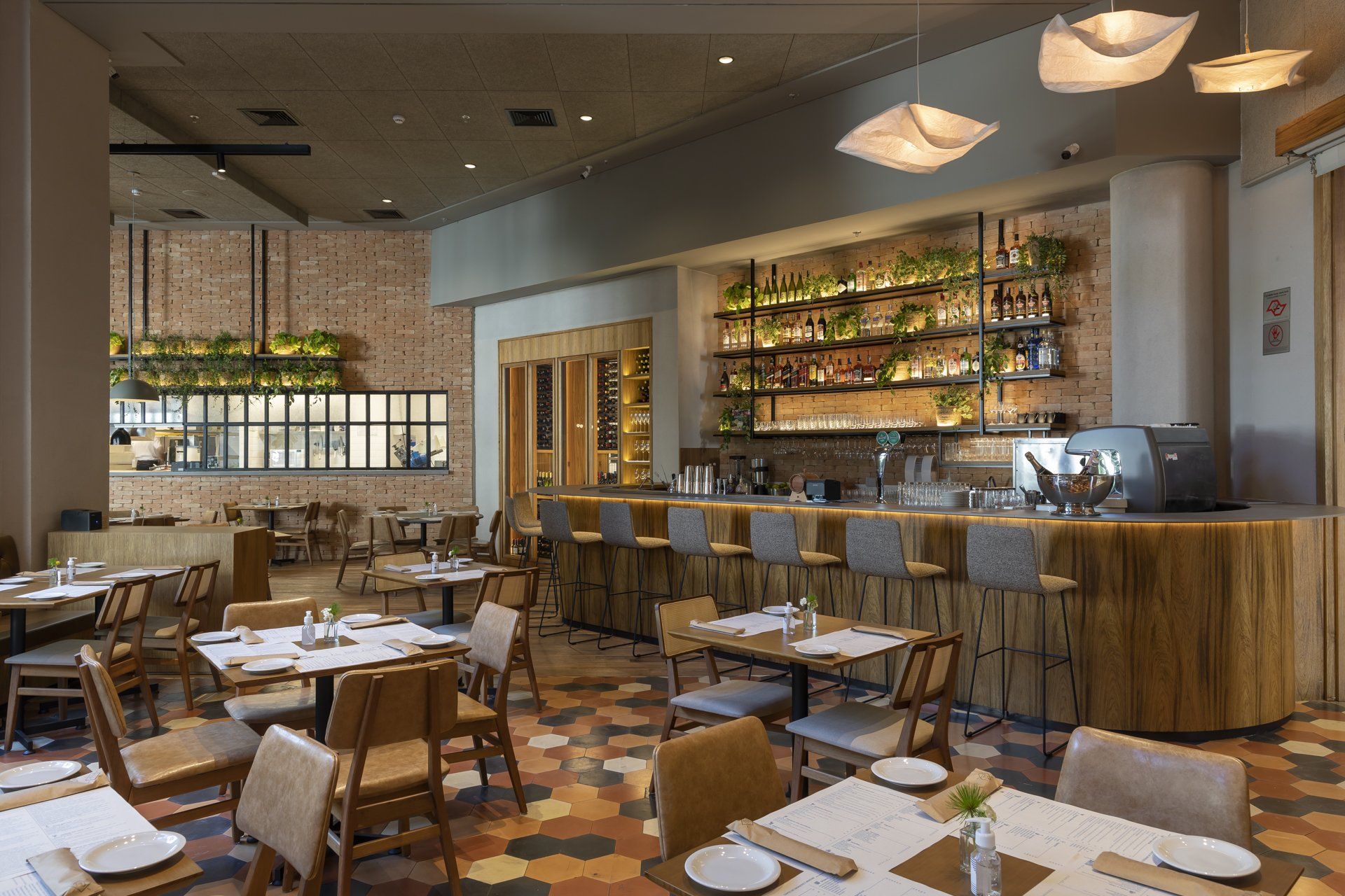 Um restaurante com mesas e cadeiras e um bar.