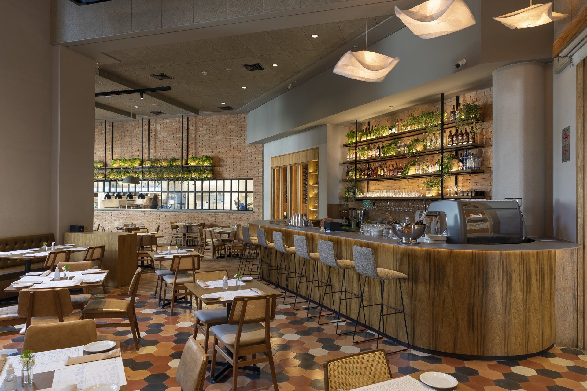 Um restaurante com mesas e cadeiras e um bar.