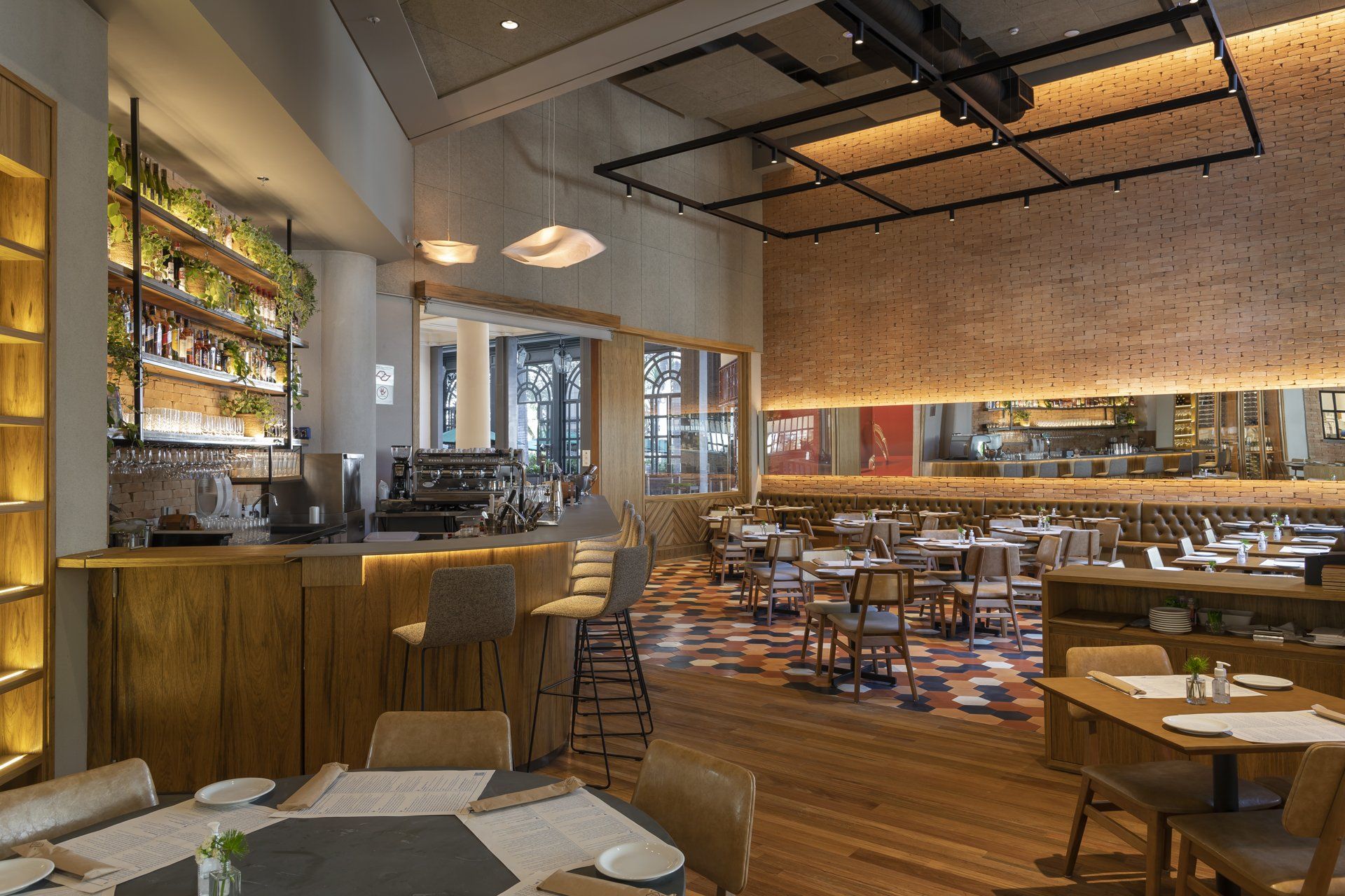 Um restaurante com mesas e cadeiras e um bar.