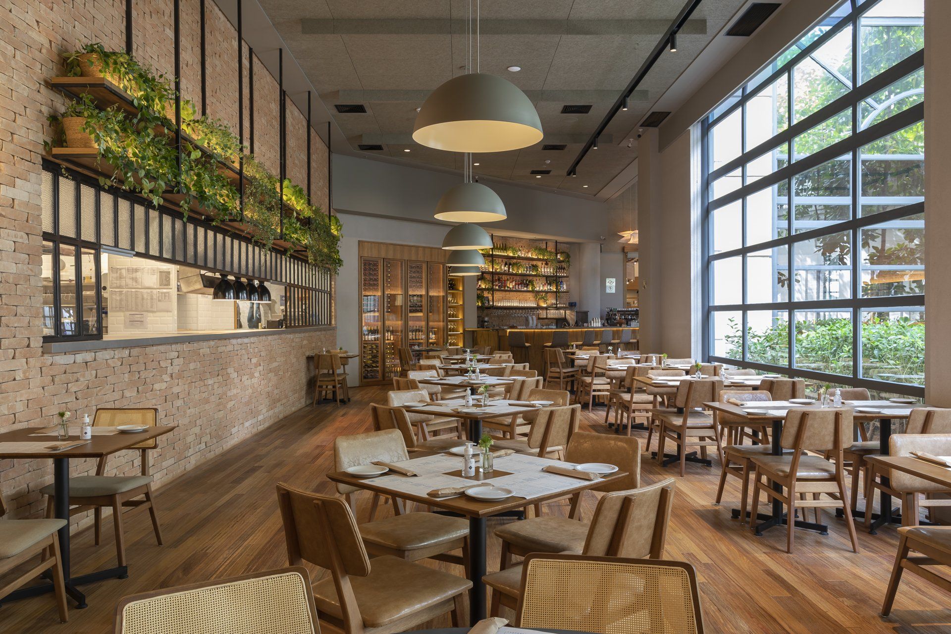 Um restaurante com mesas e cadeiras e muitas janelas.