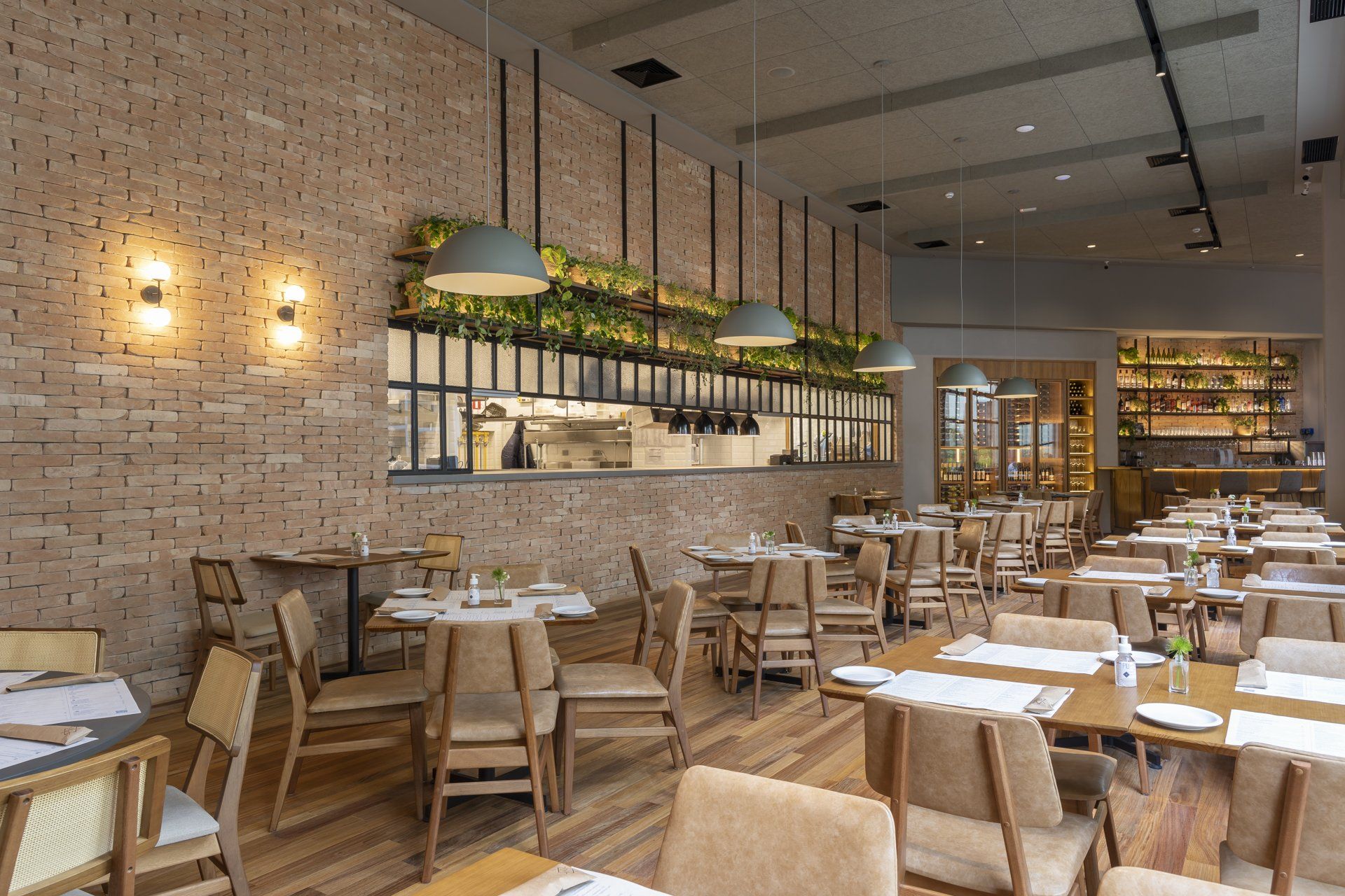 Um restaurante com mesas e cadeiras e uma parede de tijolos.