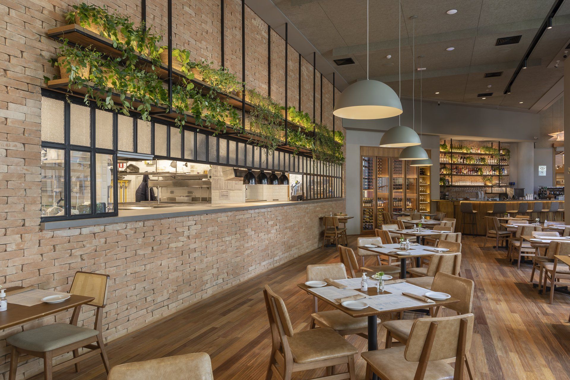 Um restaurante com mesas e cadeiras e uma parede de tijolos.