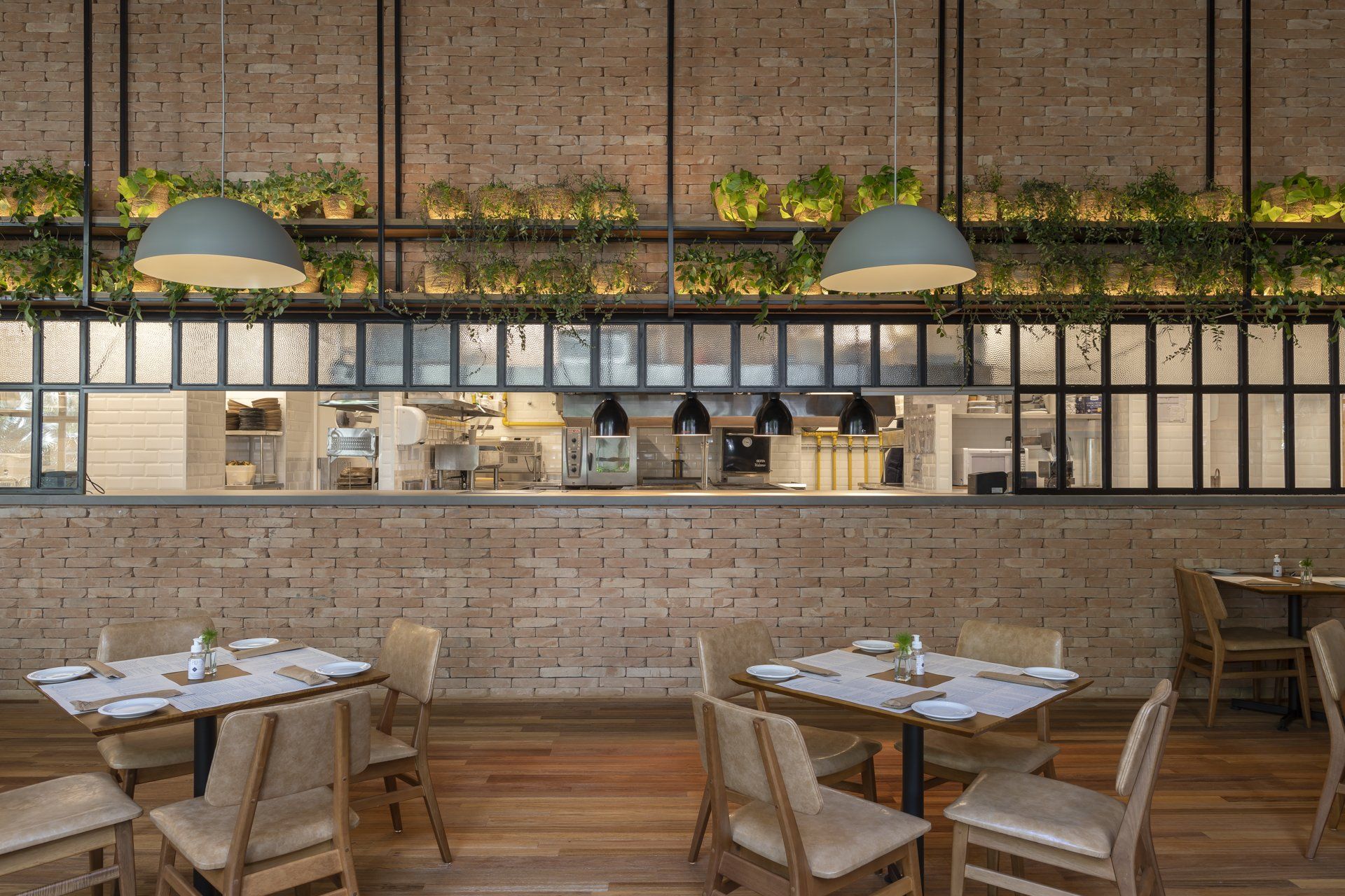 Um restaurante com mesas e cadeiras e uma parede de tijolos.
