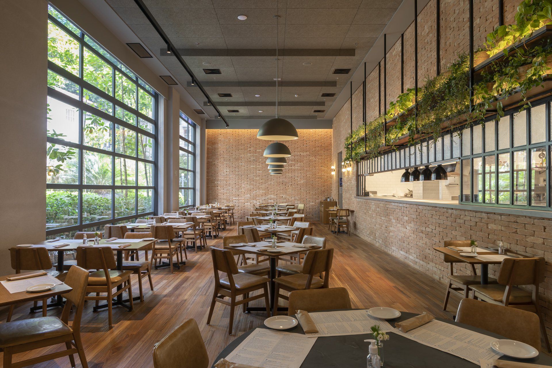 Um restaurante com mesas e cadeiras e muitas janelas