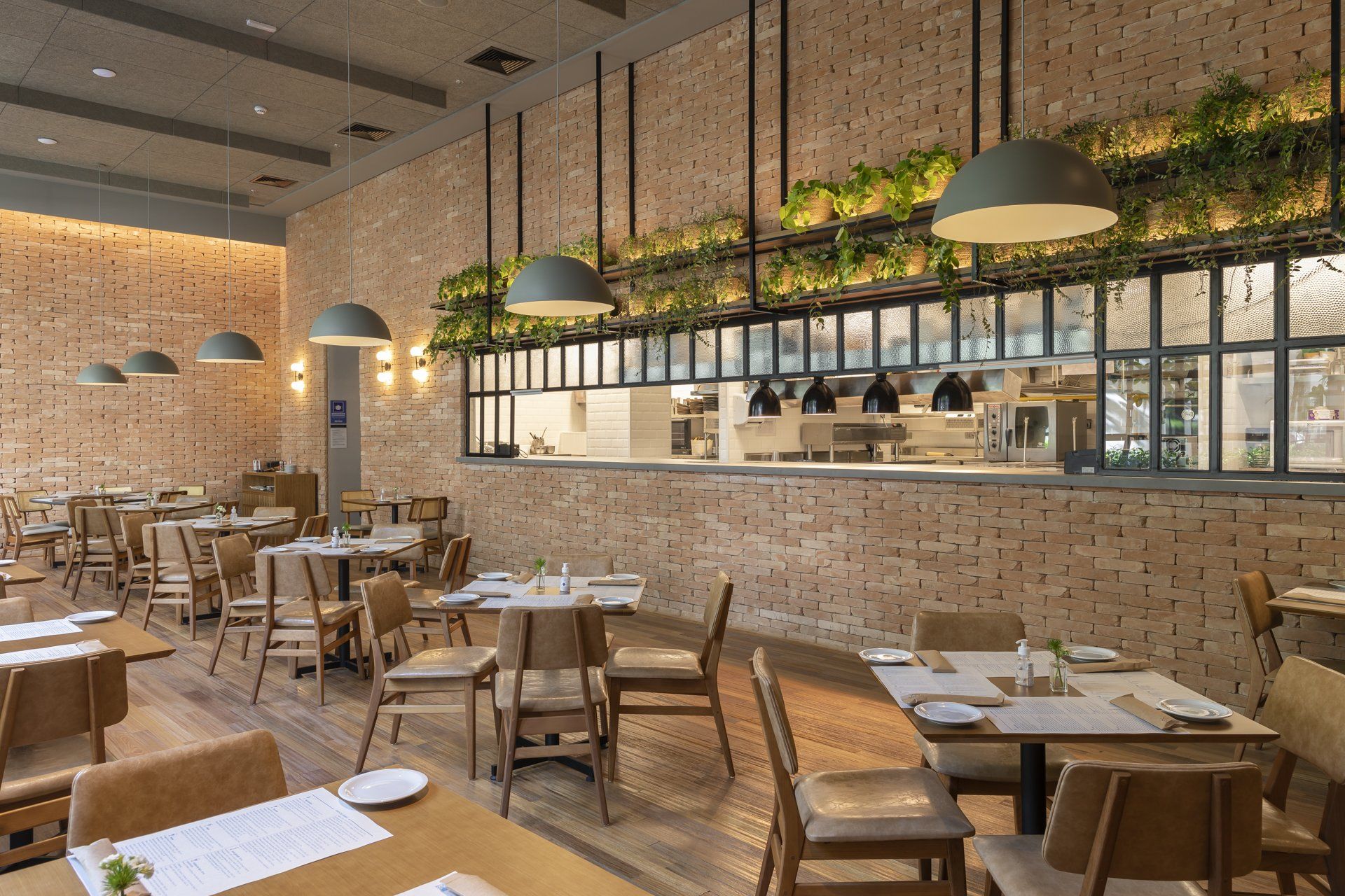 Um restaurante com mesas e cadeiras e uma parede de tijolos.