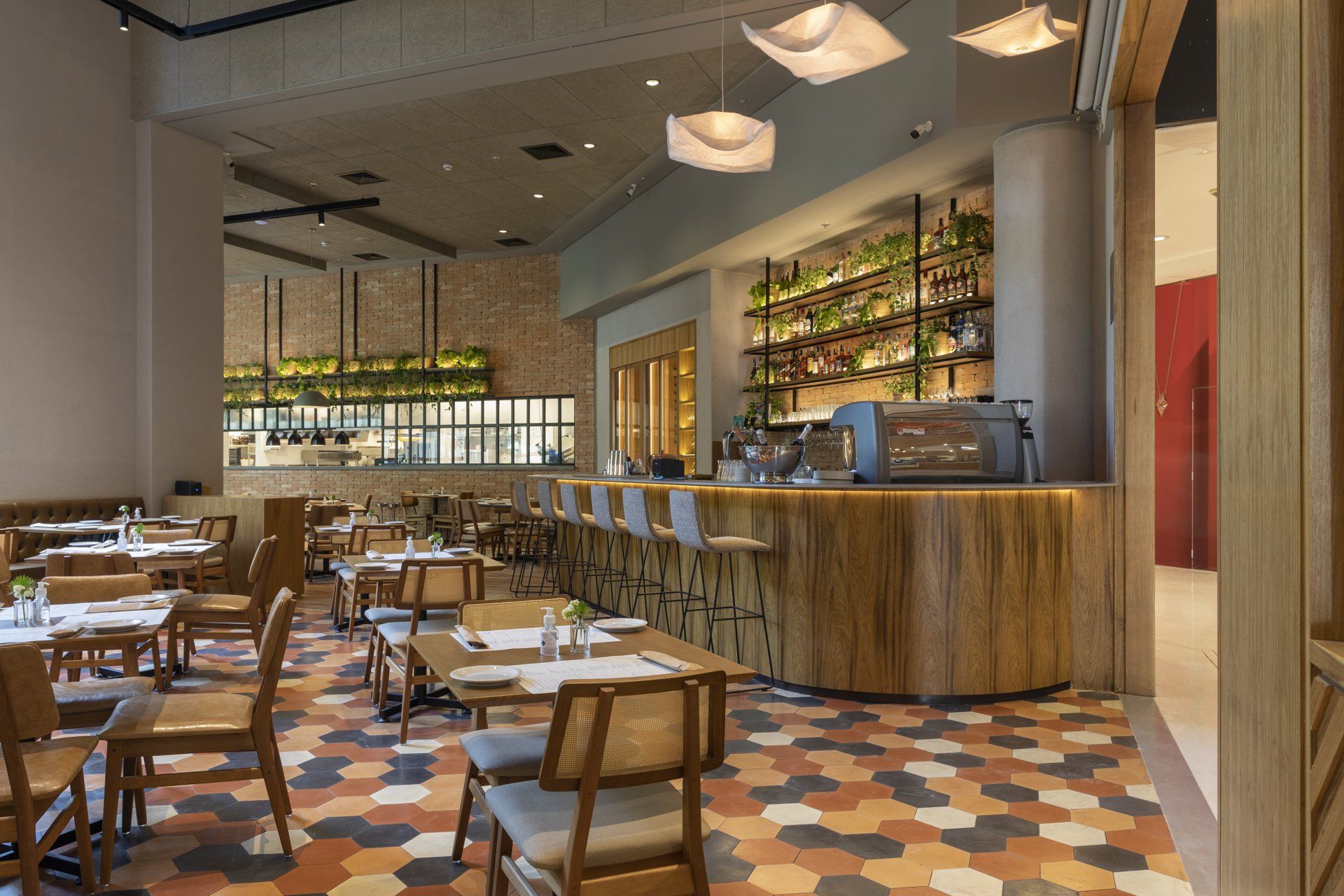 Um restaurante com mesas e cadeiras e um bar.