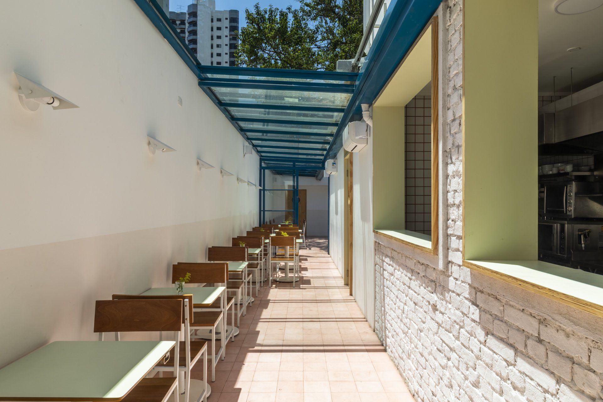 Um longo corredor com mesas e cadeiras em um restaurante