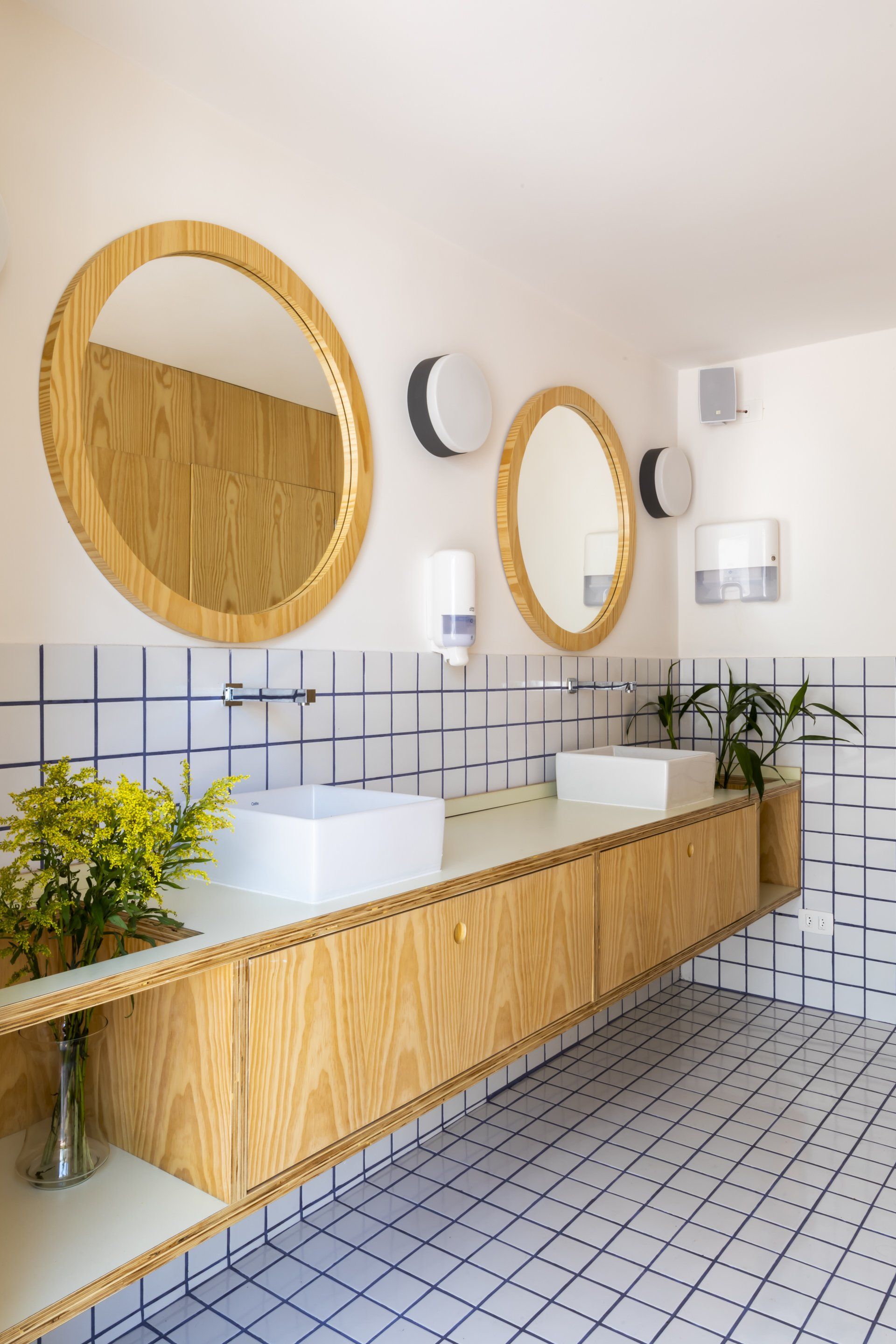 Um banheiro com duas pias e dois espelhos.