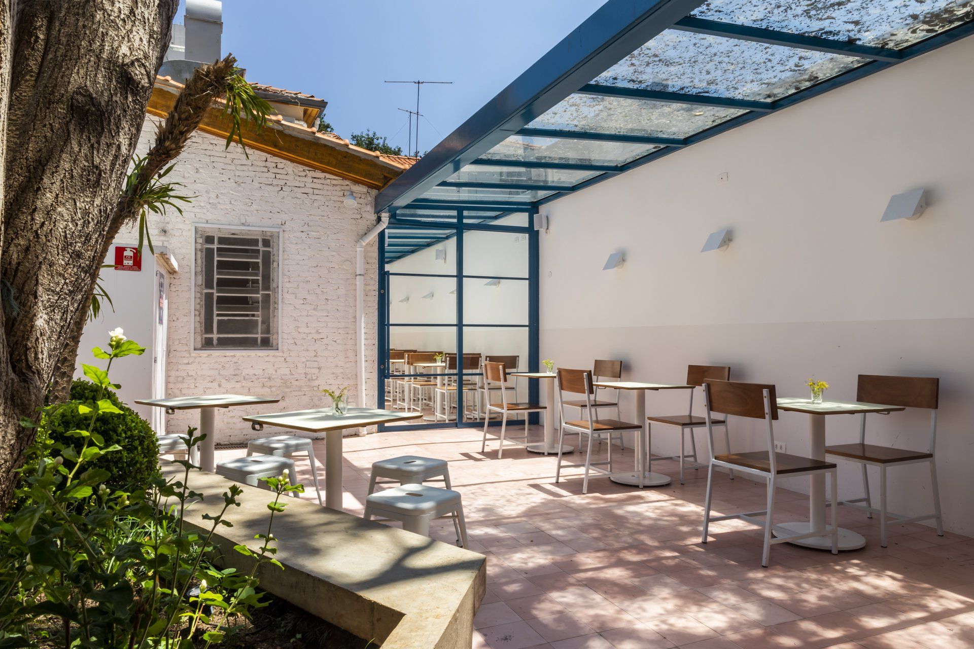 Um pátio com mesas e cadeiras sob um dossel.