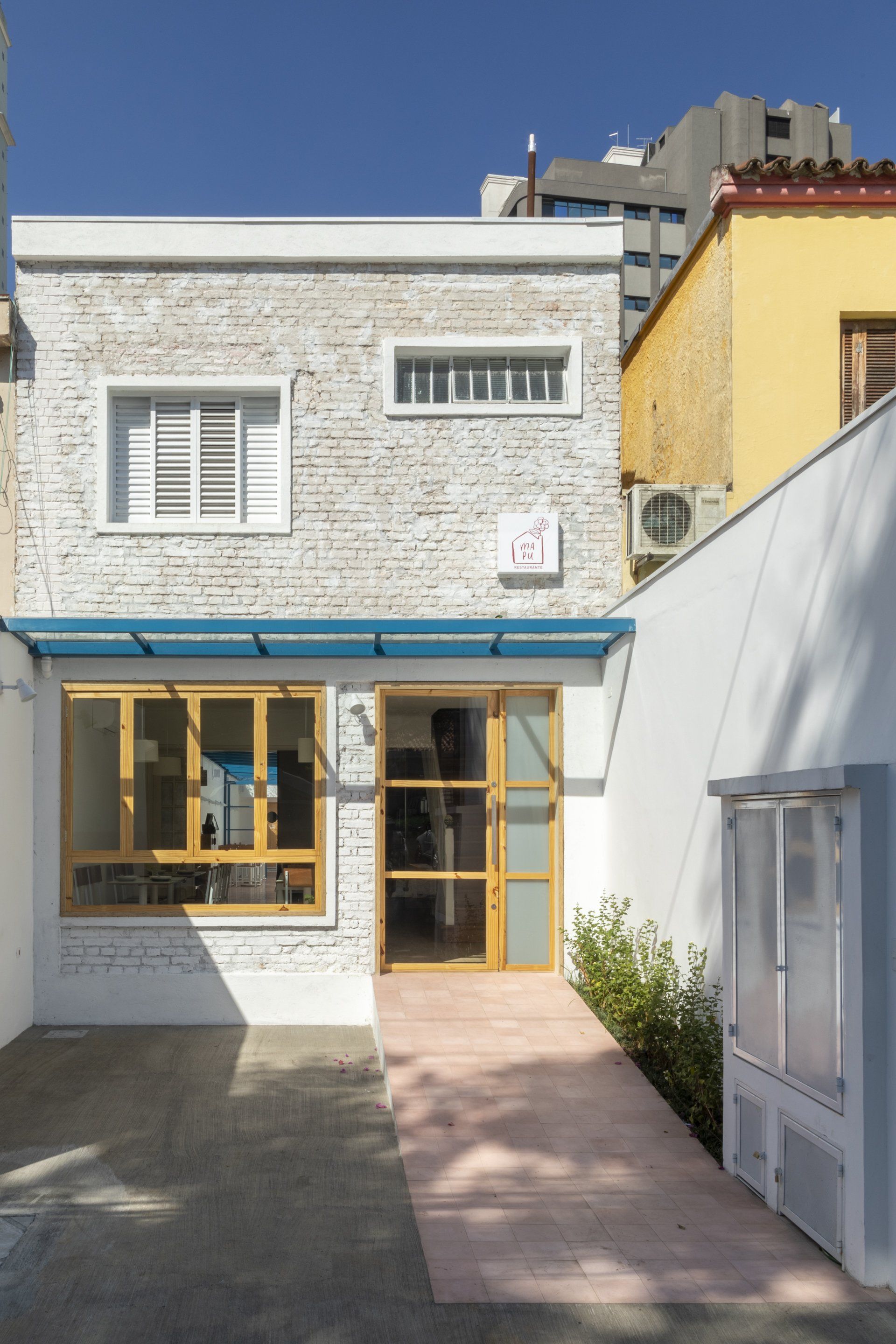 Um prédio de tijolos brancos com telhado azul