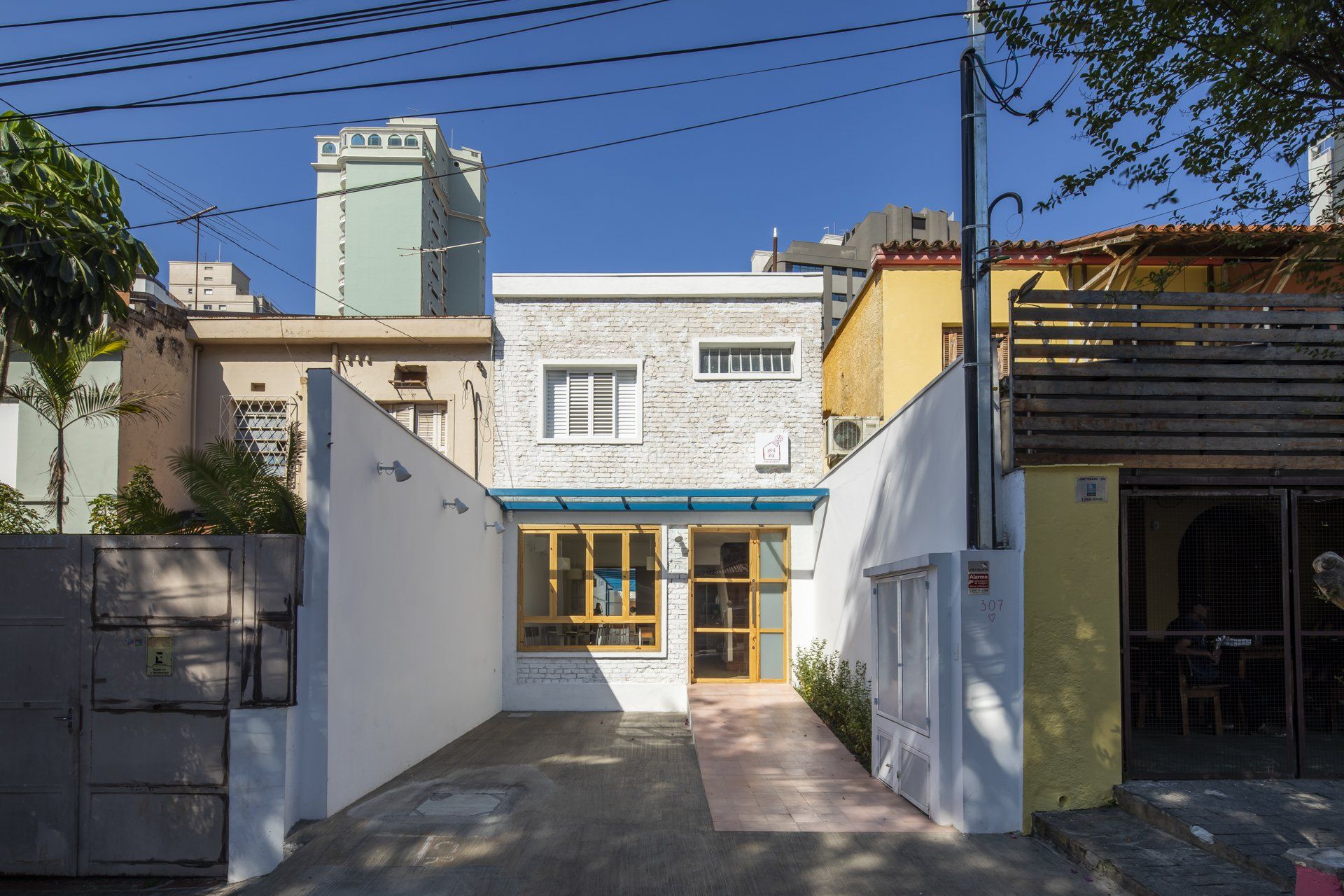 Um prédio branco com um toldo azul no topo