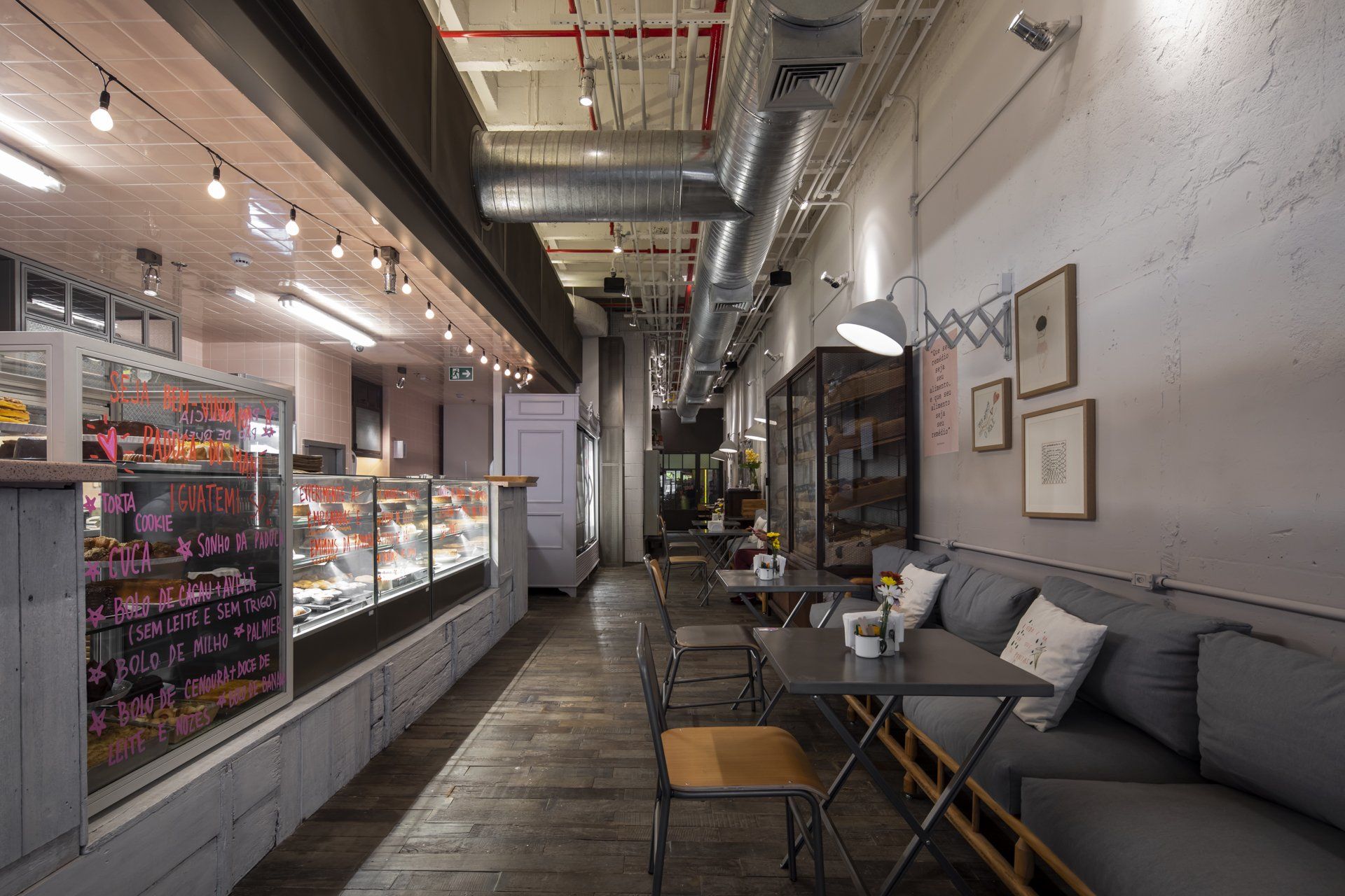 Um longo corredor de um restaurante com mesas e cadeiras.