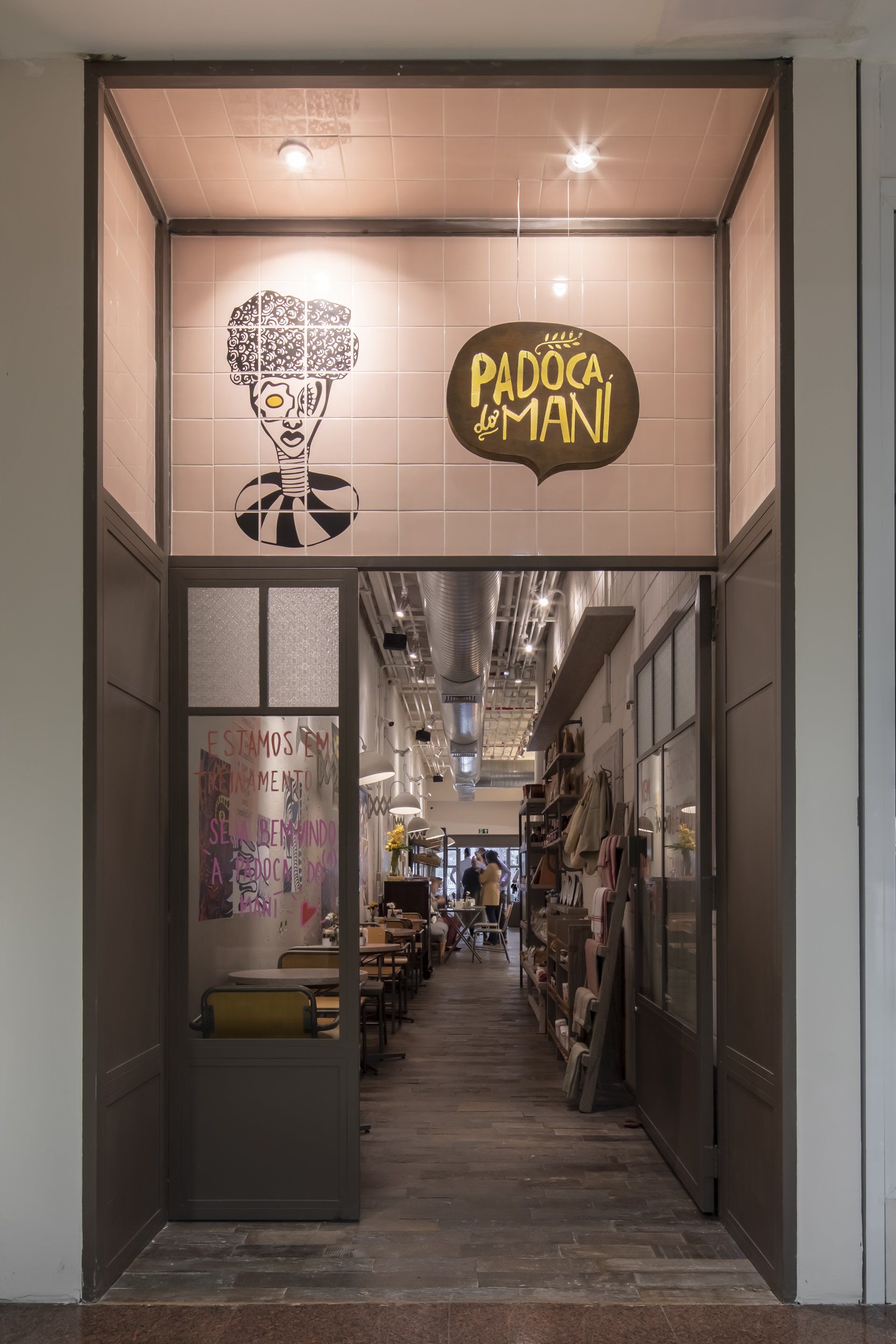 A entrada de um restaurante com uma placa que diz padoca & mani.