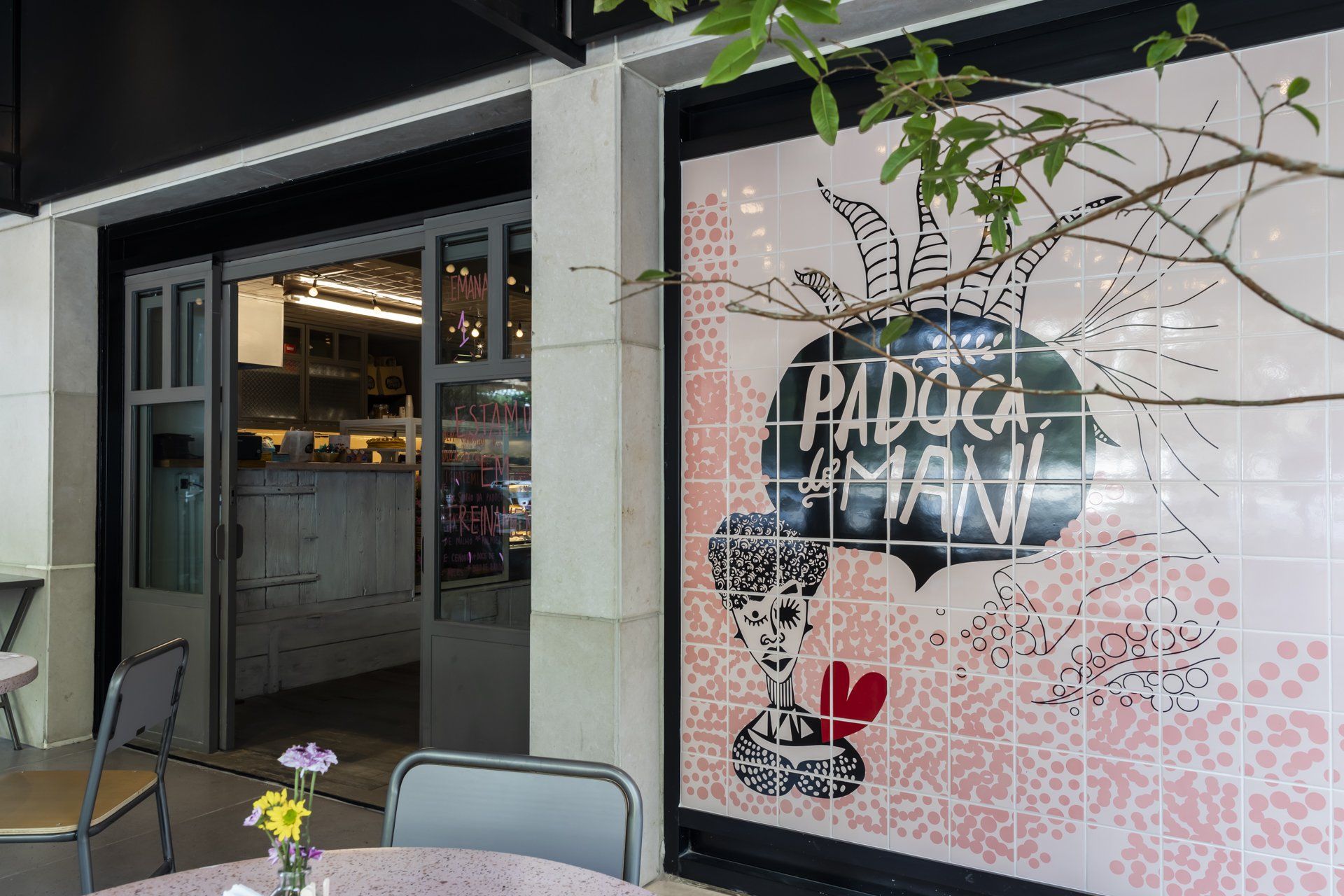 Um restaurante com mesa e cadeiras na frente.