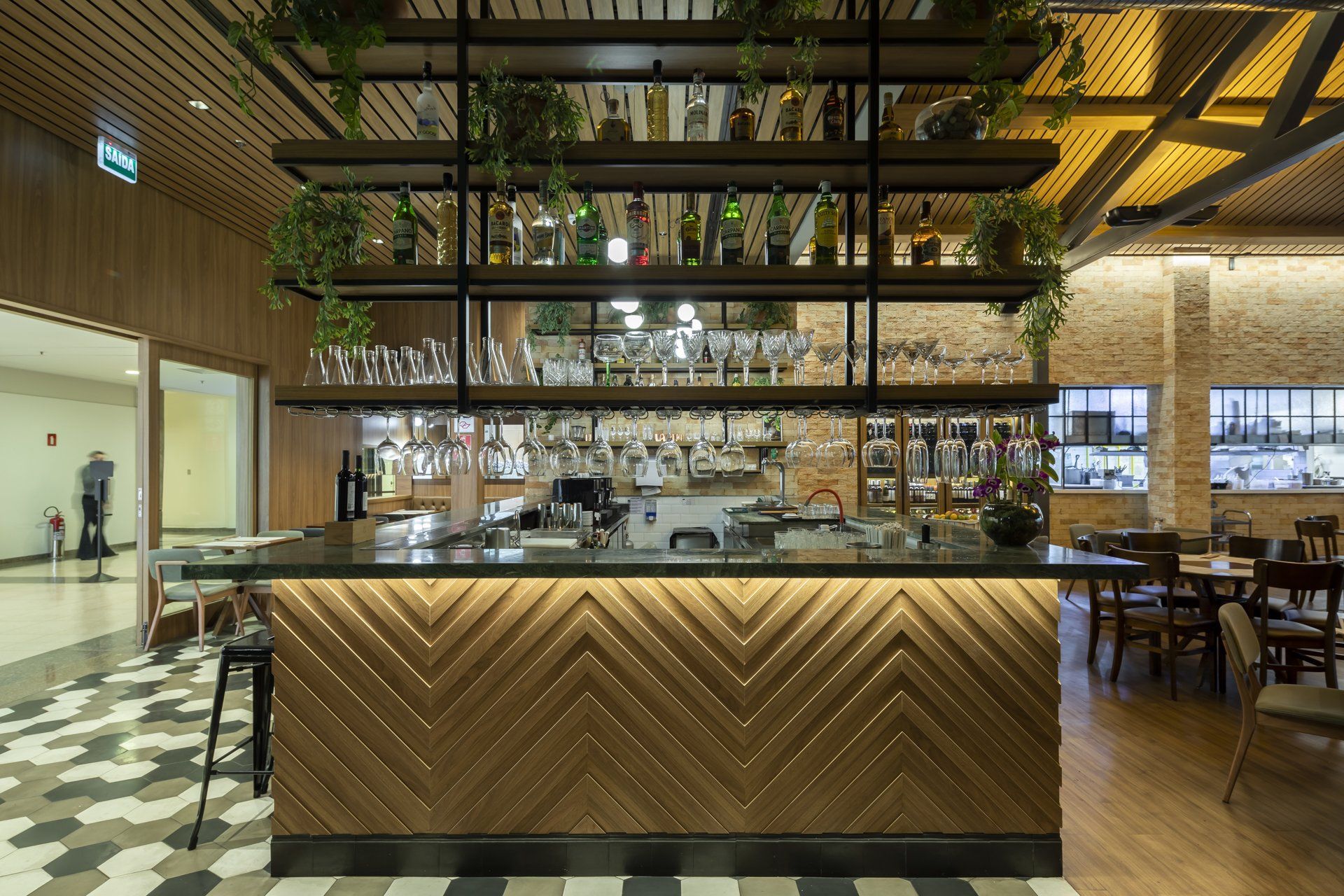 Um restaurante com bar e piso xadrez.