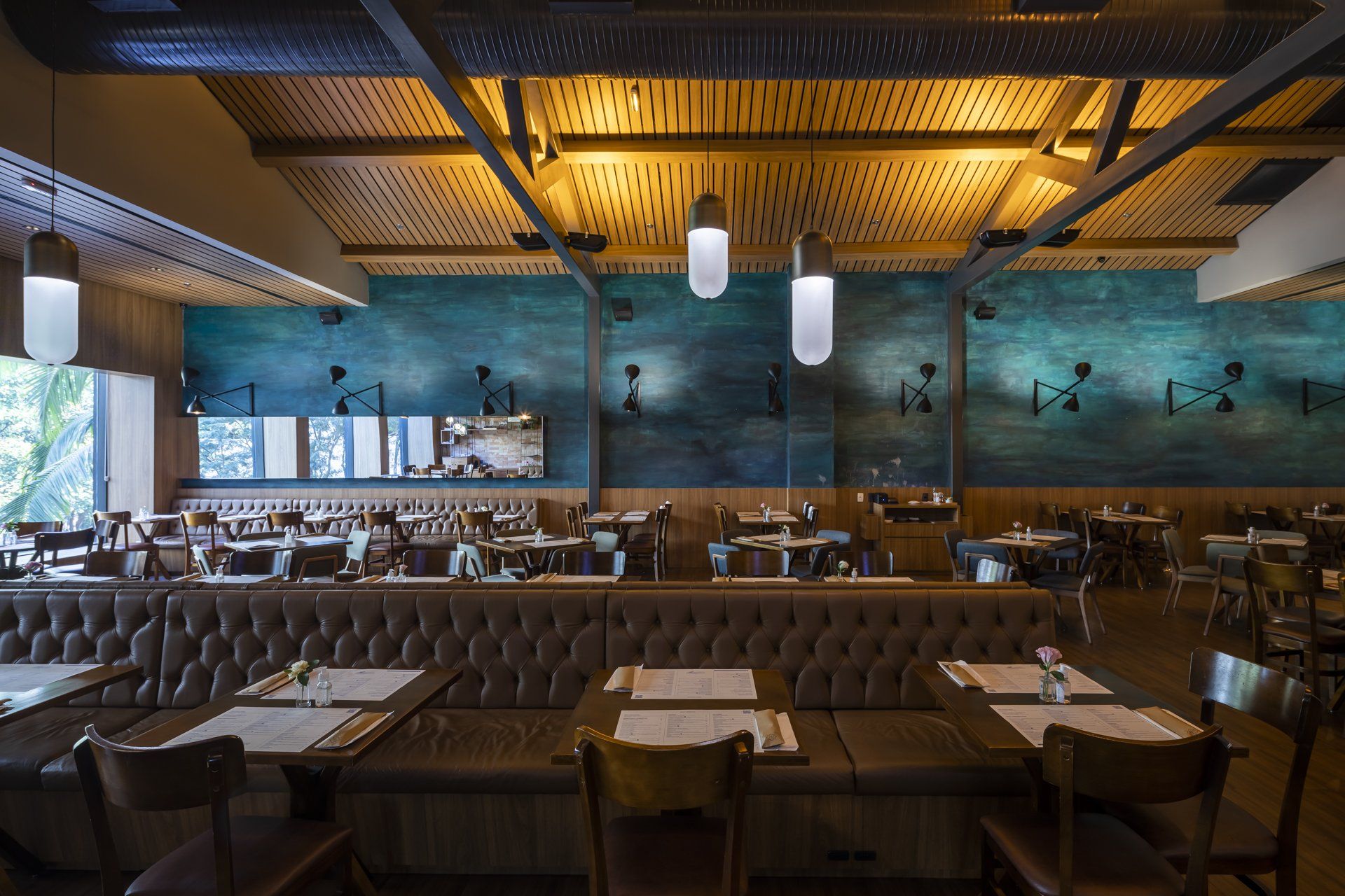 Um restaurante com mesas e cadeiras e uma parede azul