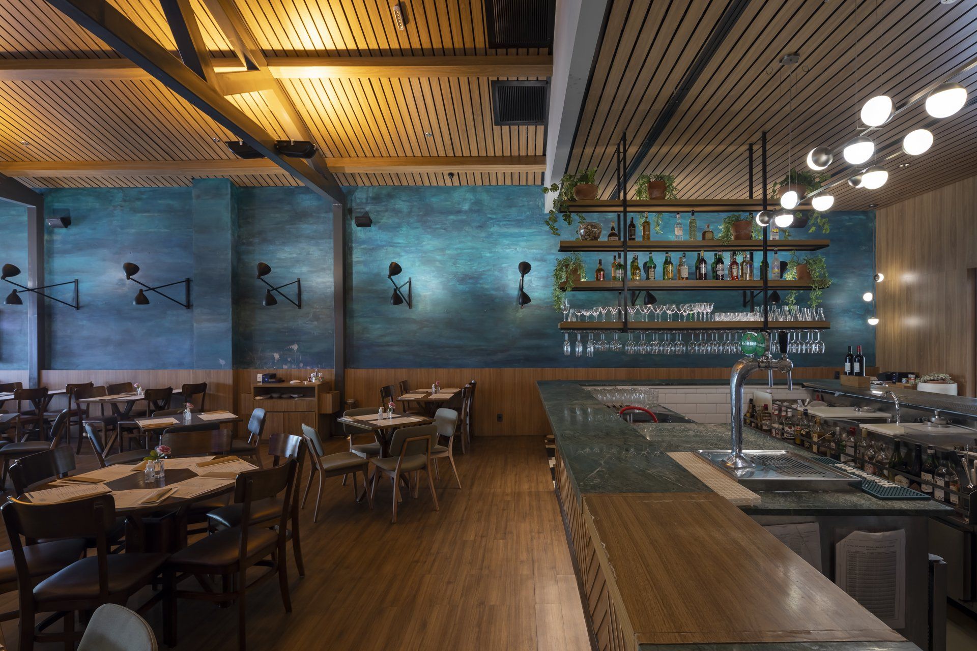 Um restaurante com mesas e cadeiras e um bar.