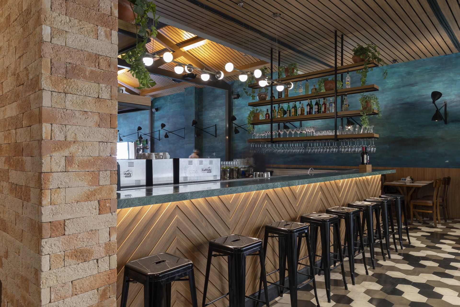 Um bar com bancos e uma parede de tijolos em um restaurante.