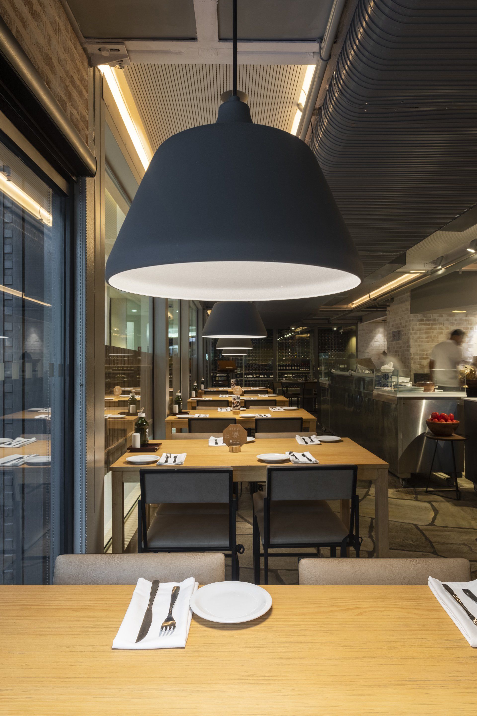 Um restaurante com mesas e cadeiras e pratos.