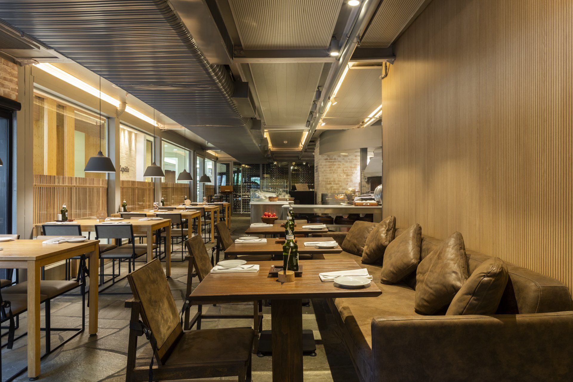 Um restaurante com mesas e cadeiras e um sofá.