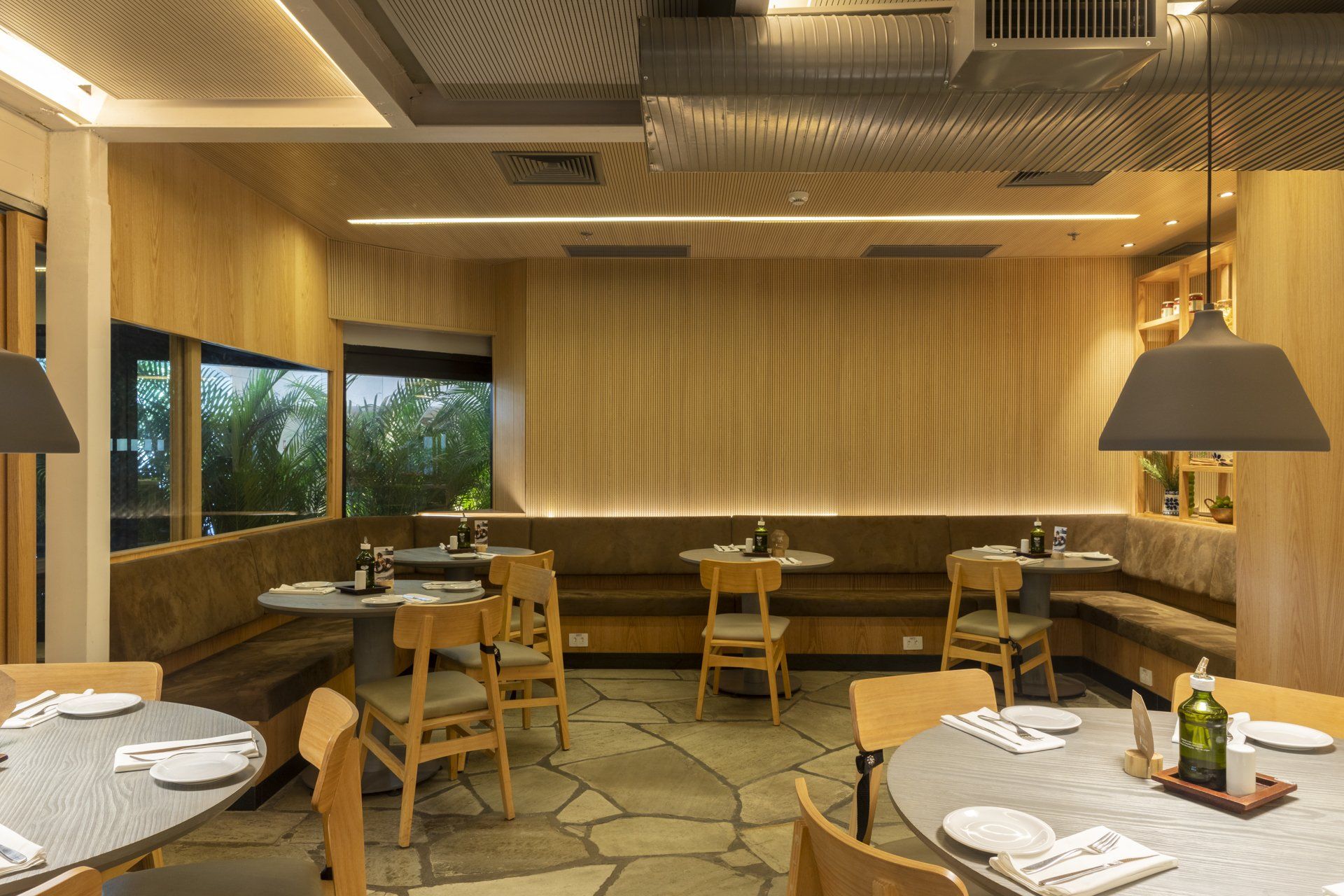 Um restaurante com mesas e cadeiras e uma grande janela.