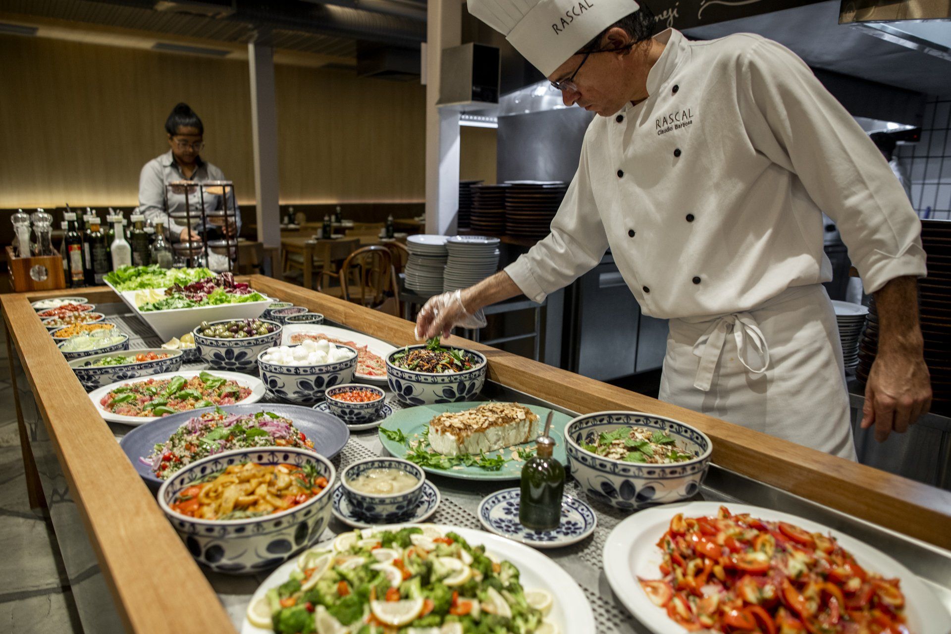 Um chef está preparando comida em uma mesa de buffet em um restaurante.