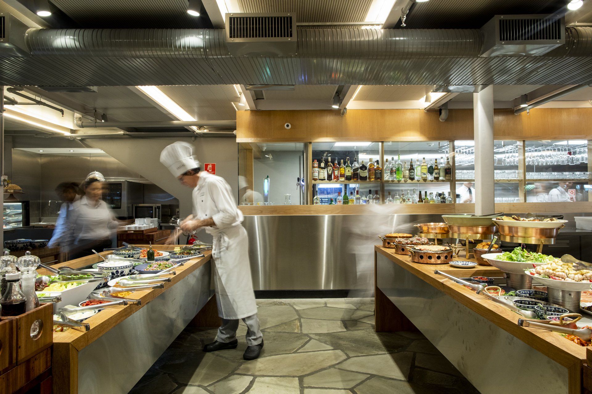 Um chef está preparando comida em um buffet em um restaurante.