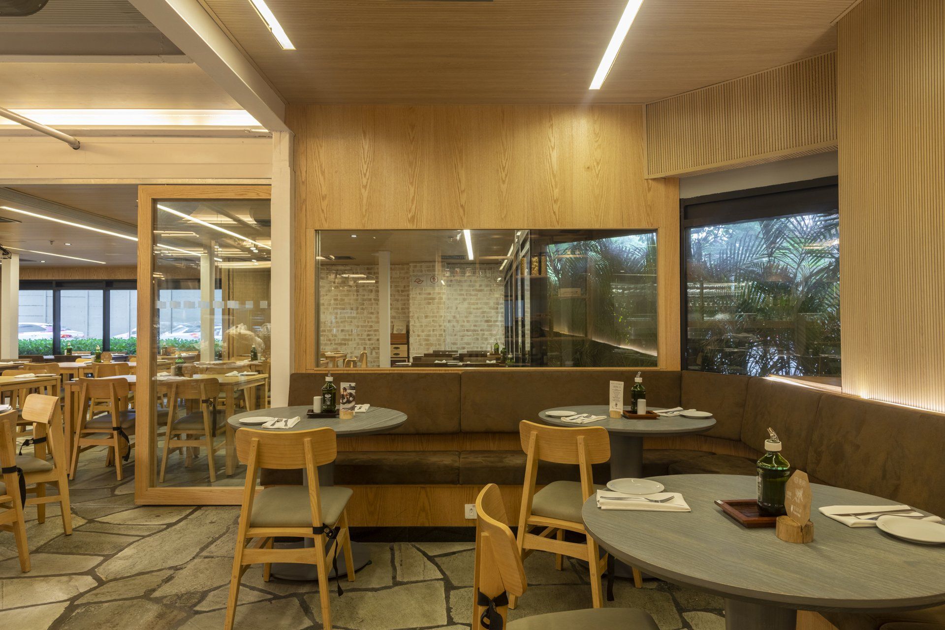 Um restaurante com mesas e cadeiras e uma grande janela.