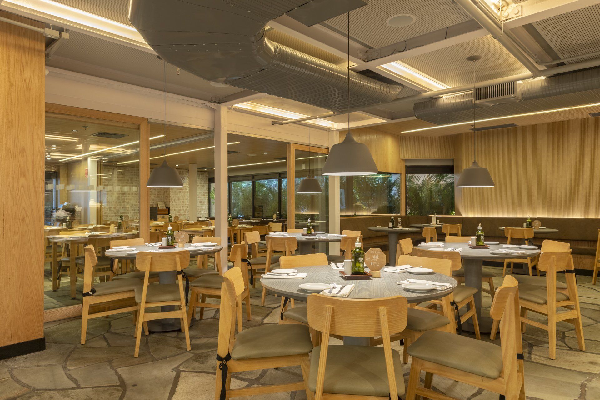 Uma grande sala de jantar com mesas e cadeiras em um restaurante.