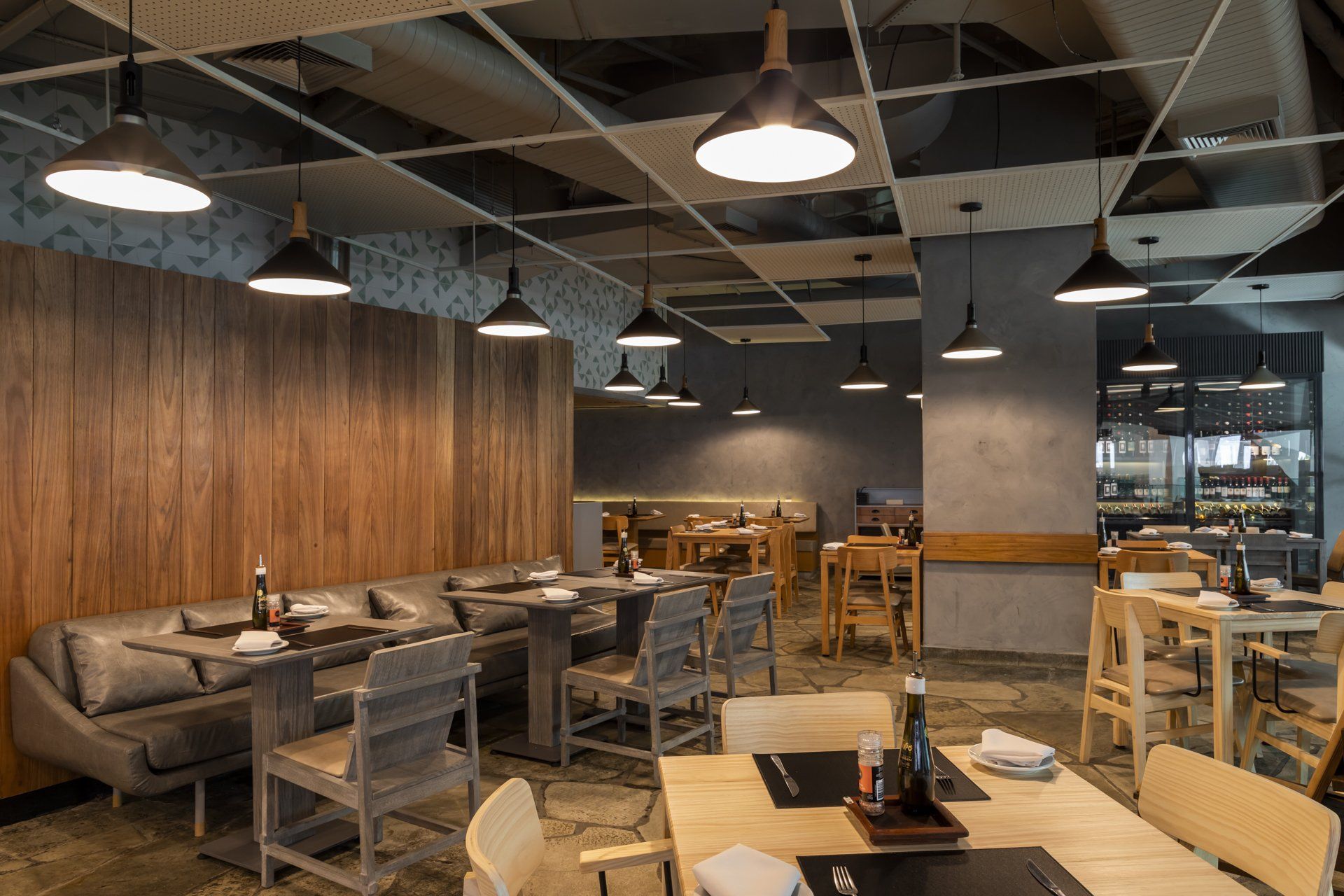 Um restaurante com mesas e cadeiras e muitas luzes penduradas no teto.