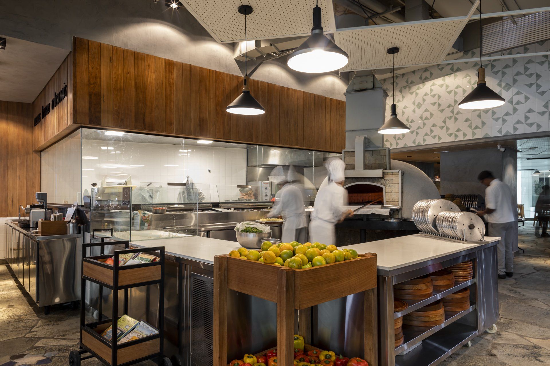 Uma cozinha com forno de pizza e uma caixa de frutas de madeira.