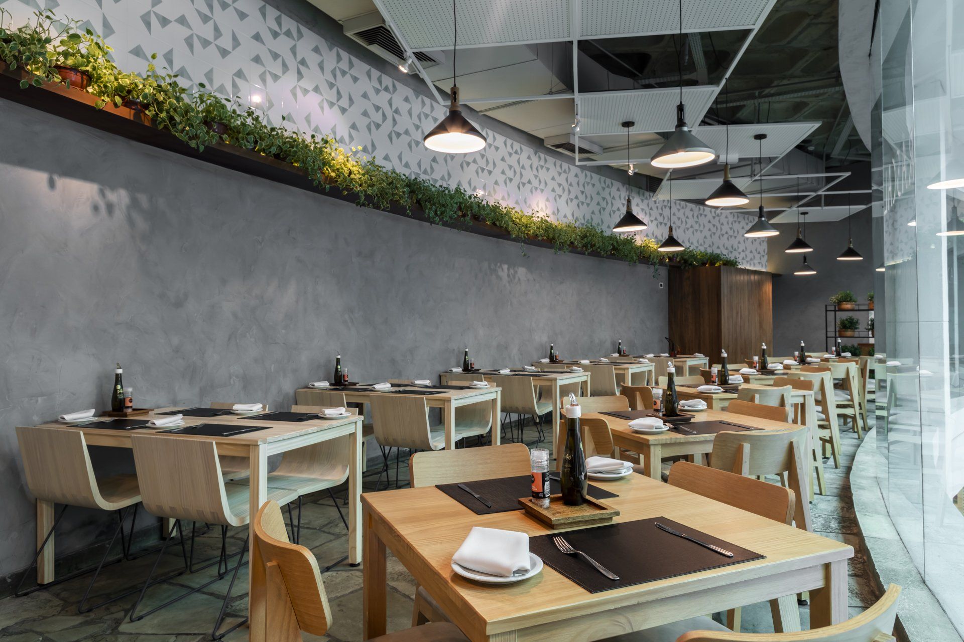 Um restaurante com mesas e cadeiras e uma grande janela.