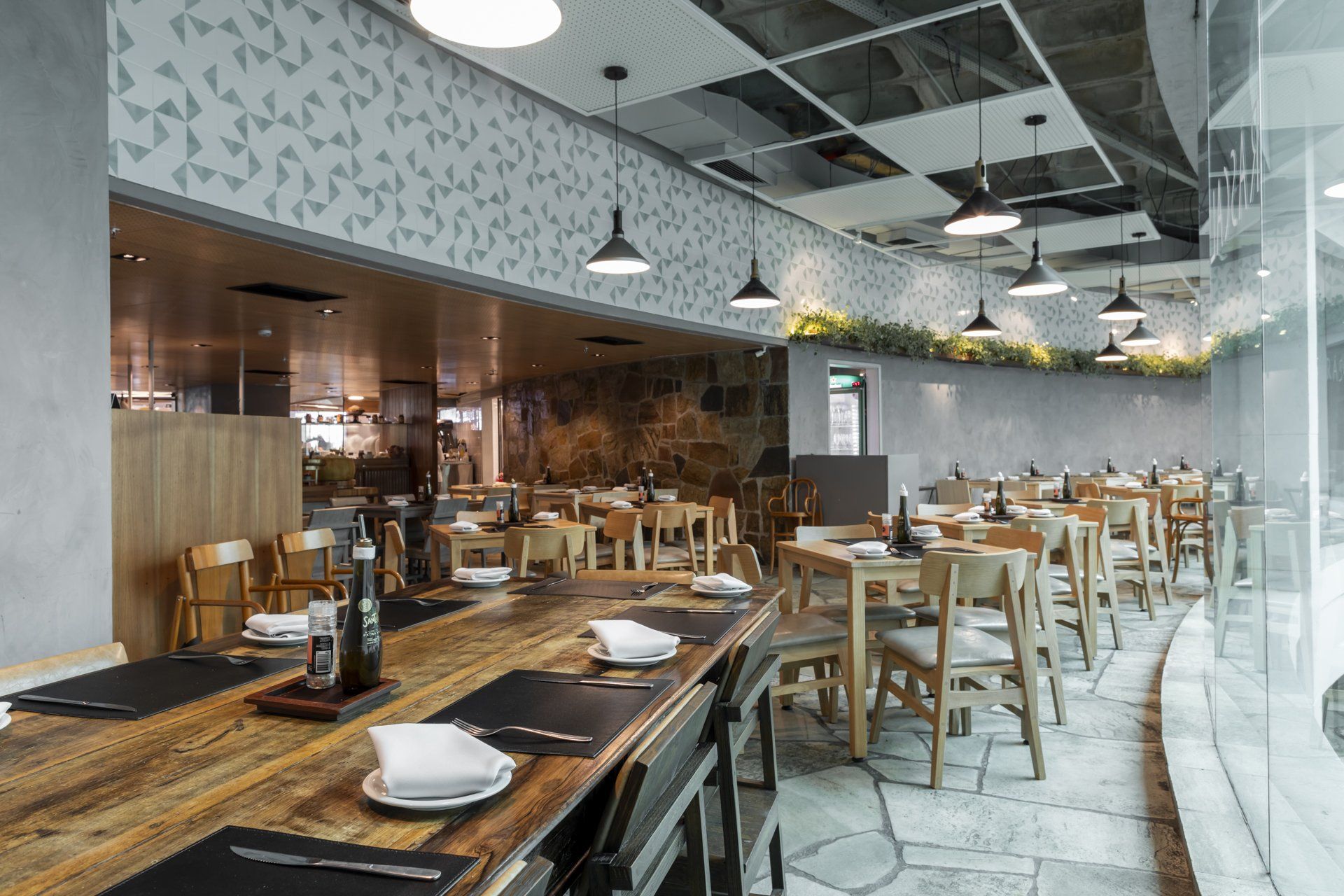 Um restaurante com mesas e cadeiras e uma grande janela.