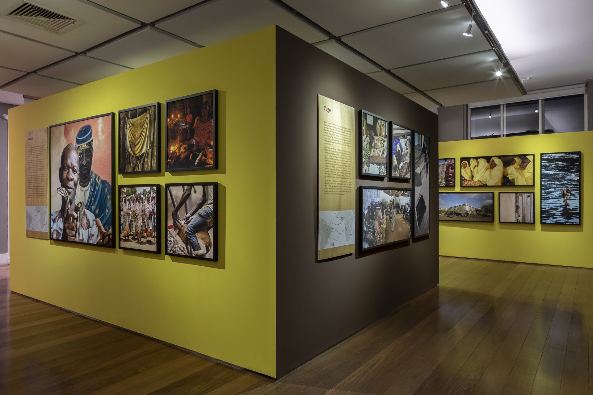 Uma sala com muitos quadros na parede e piso de madeira.