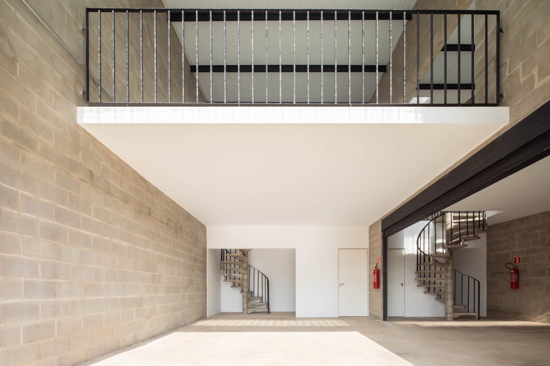 Uma grande sala vazia com varanda e escadas.