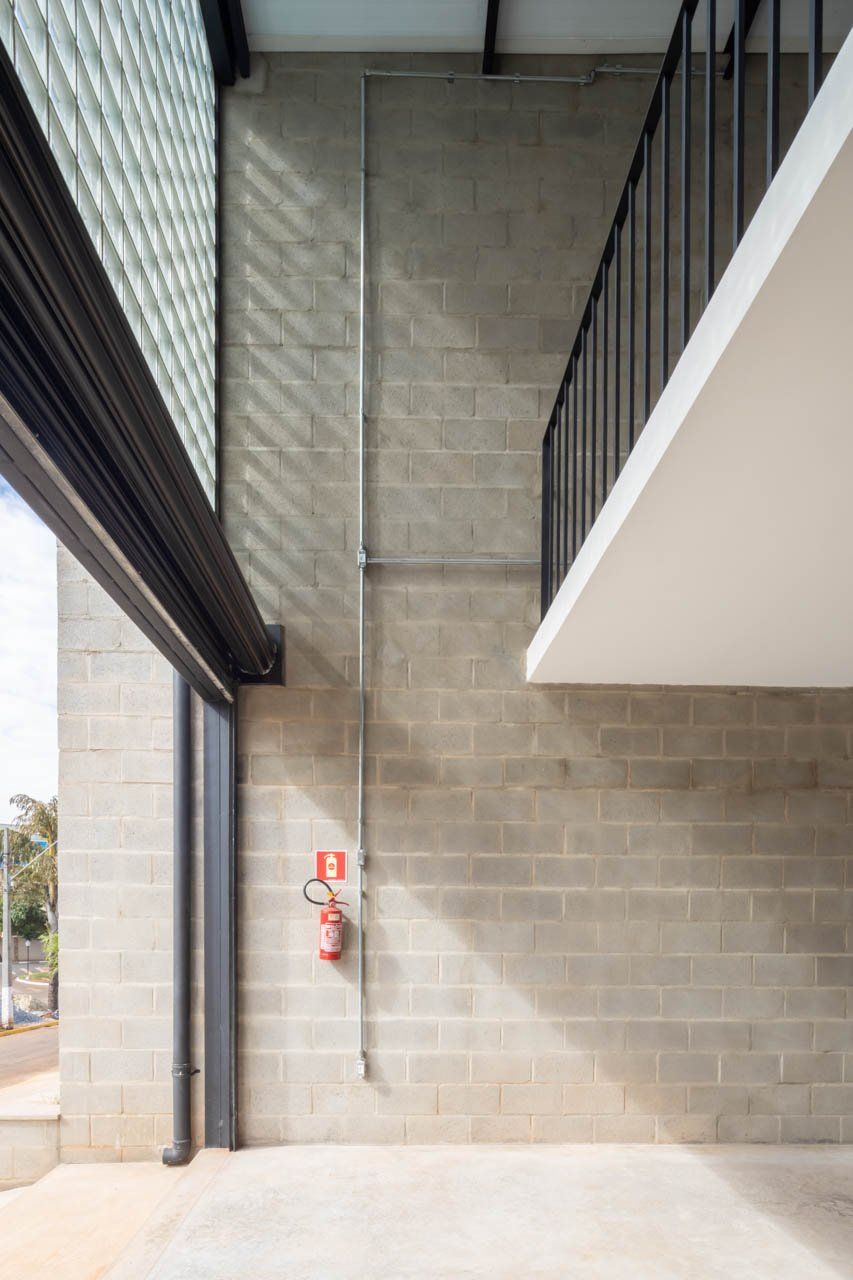 Uma parede de tijolos com um extintor de incêndio em um prédio.